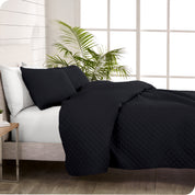 A coverlet set on a bed next to a window