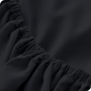 A close up of the elastic of a microfiber fitted sheet. 