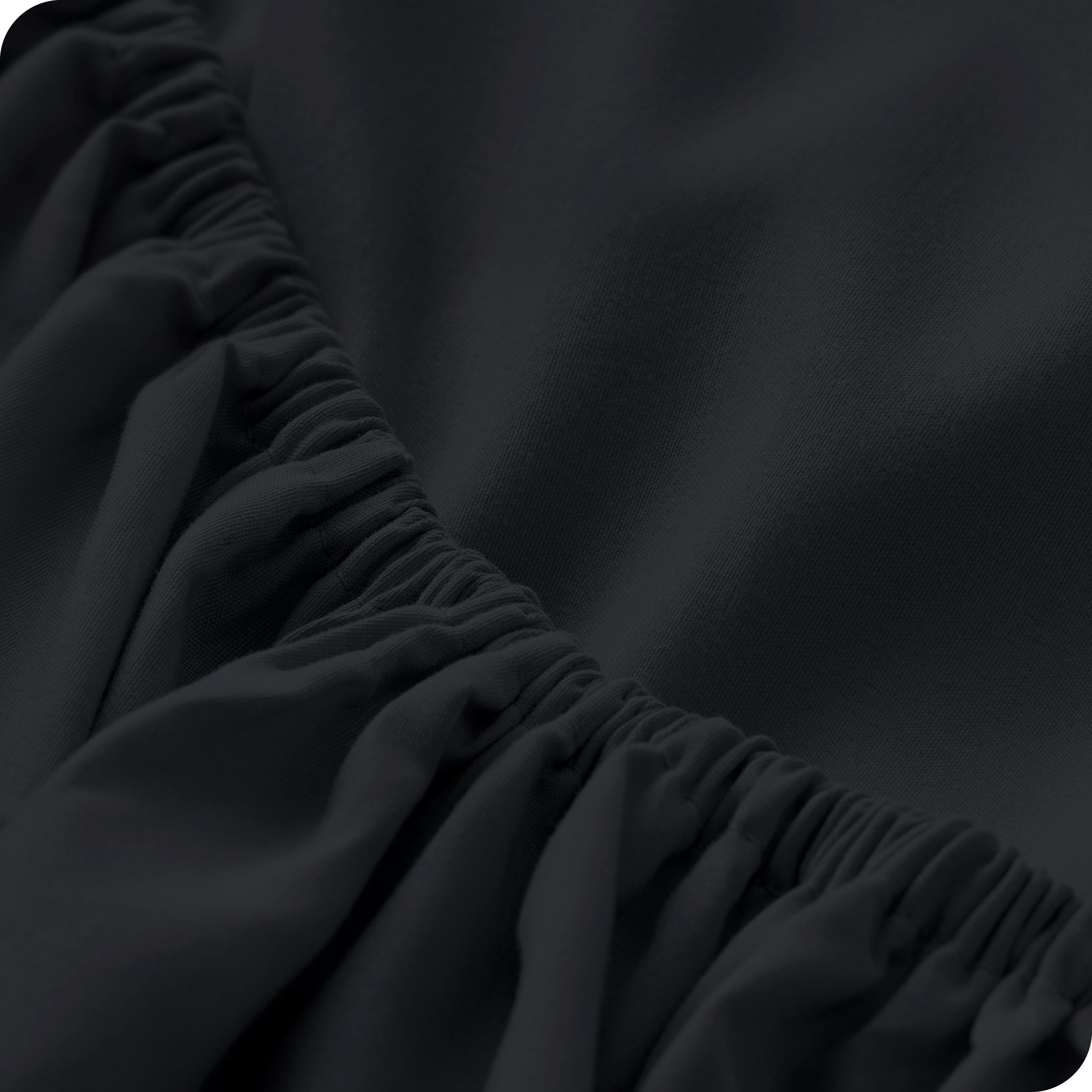 A close up of the elastic of a microfiber fitted sheet. 