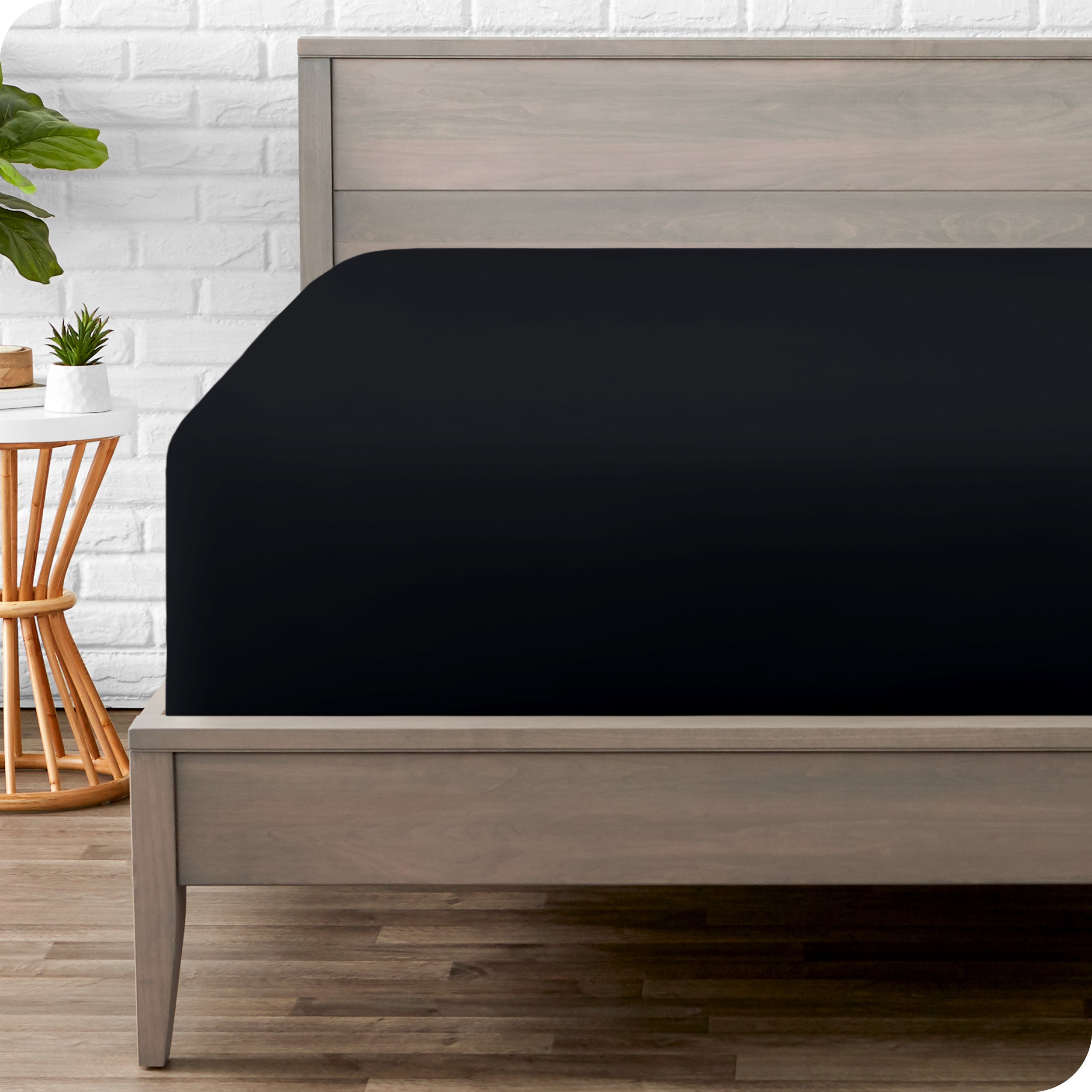 A modern bed with a fitted microfiber sheet on it