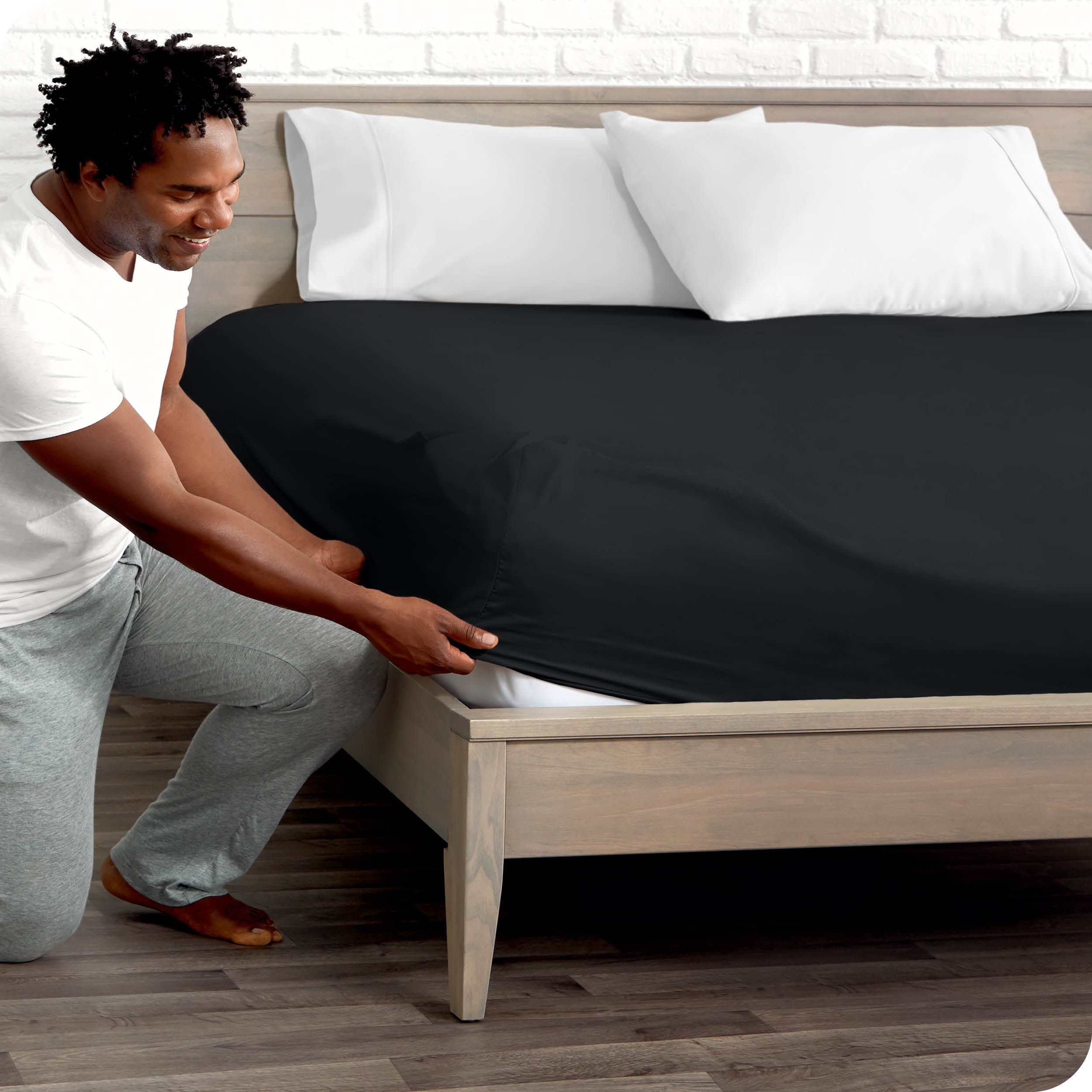 A man putting the microfiber fitted sheet on a mattress. 