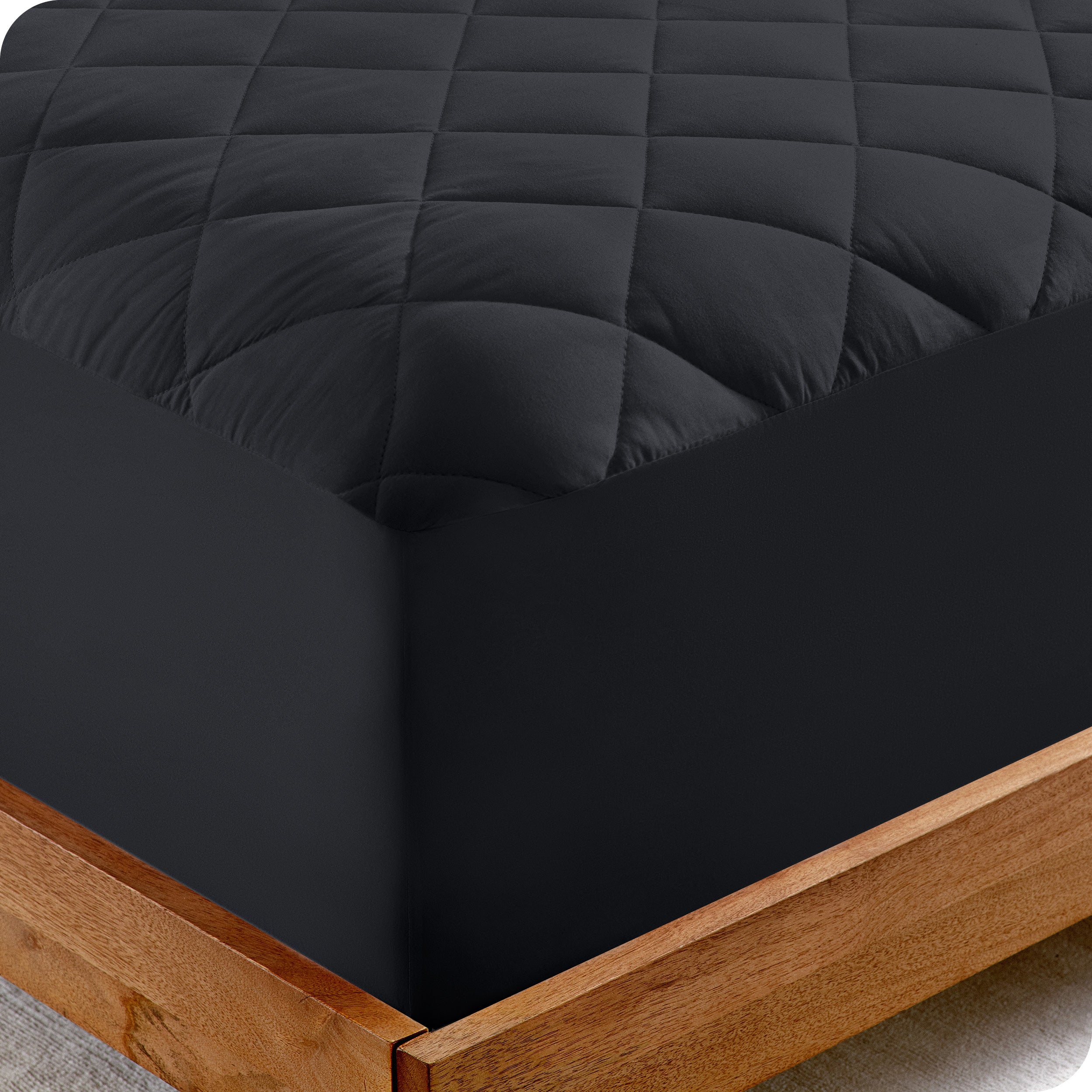 The corner of a bed showing the texture of the quilted mattress pad.
