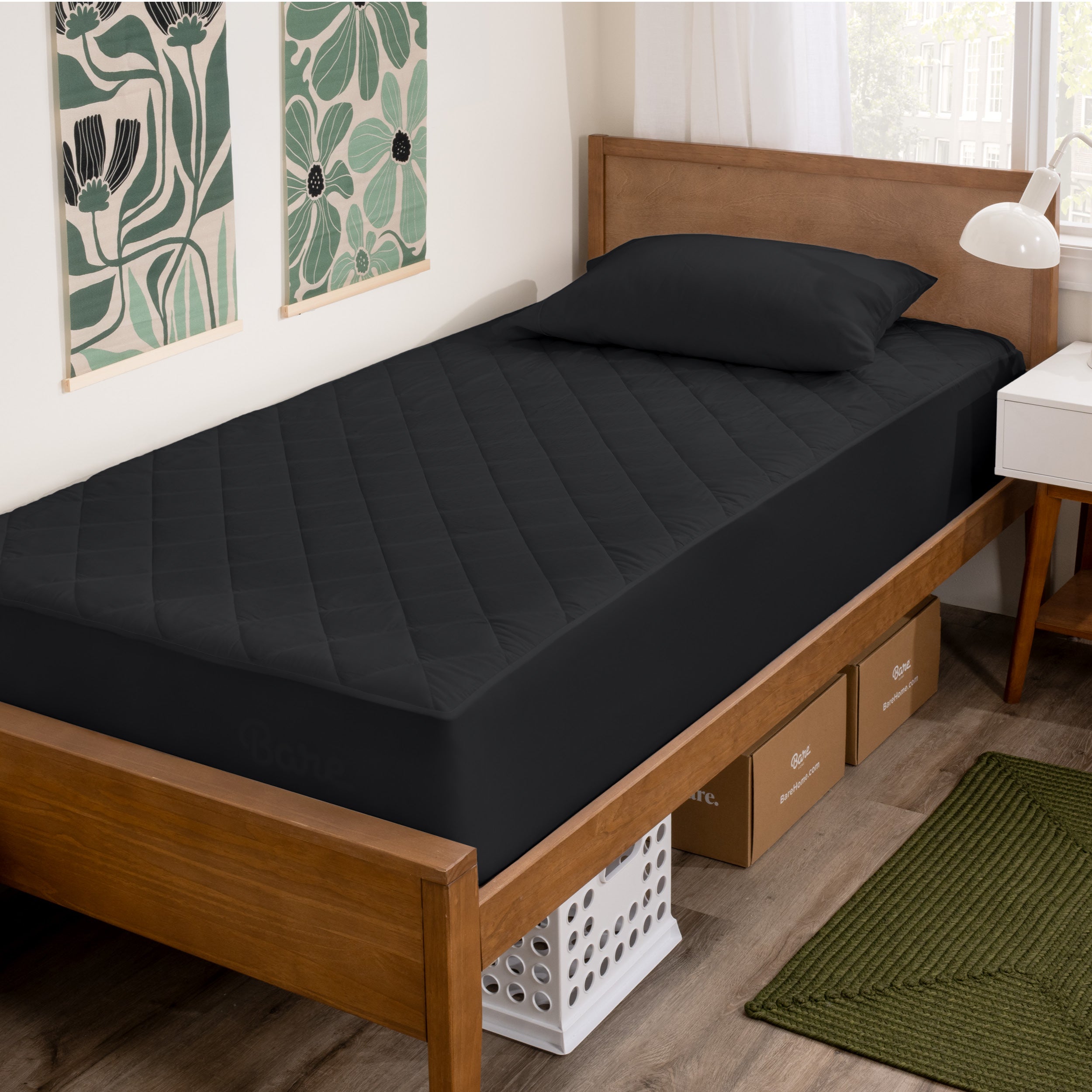 A bed with a wooden bed frame with a quilted mattress pad on.