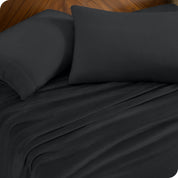 Two pillows with pillowcases on them set on a bed with matching sheets