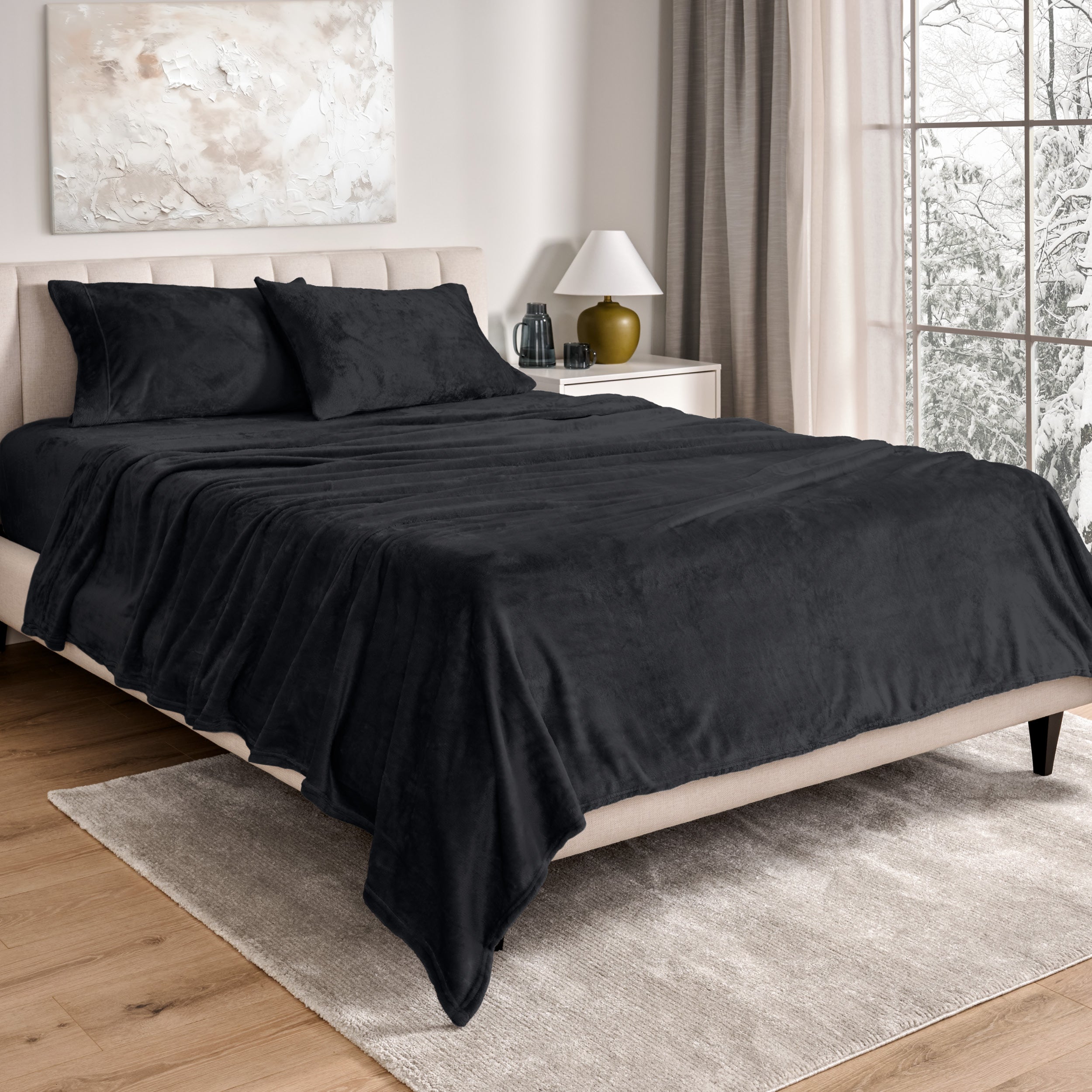 Sheets and matching pillowcases on a bed in a bedroom with a lamp and window in the background.