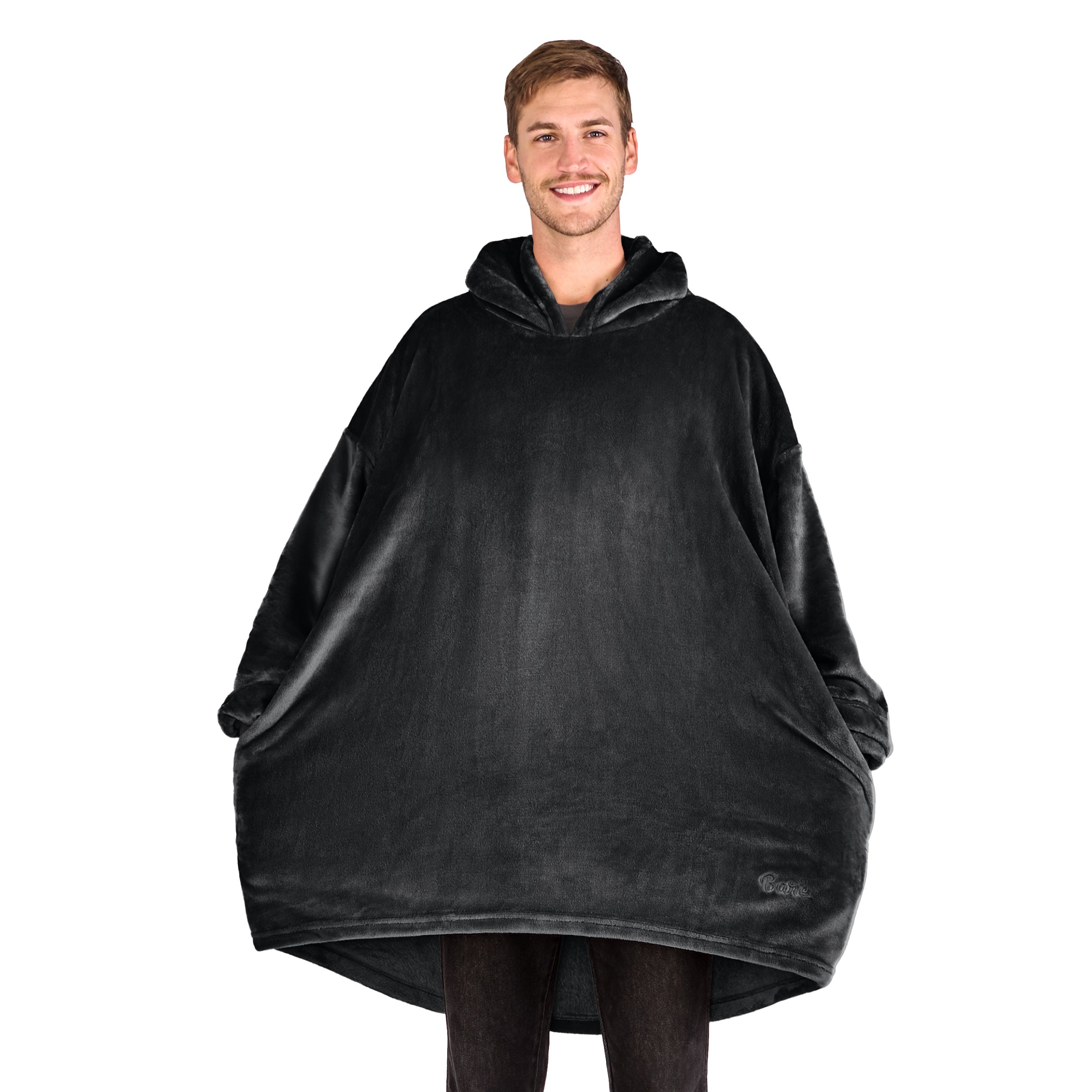 A man has a microplush wearable blanket on and his hands are in the side pockets