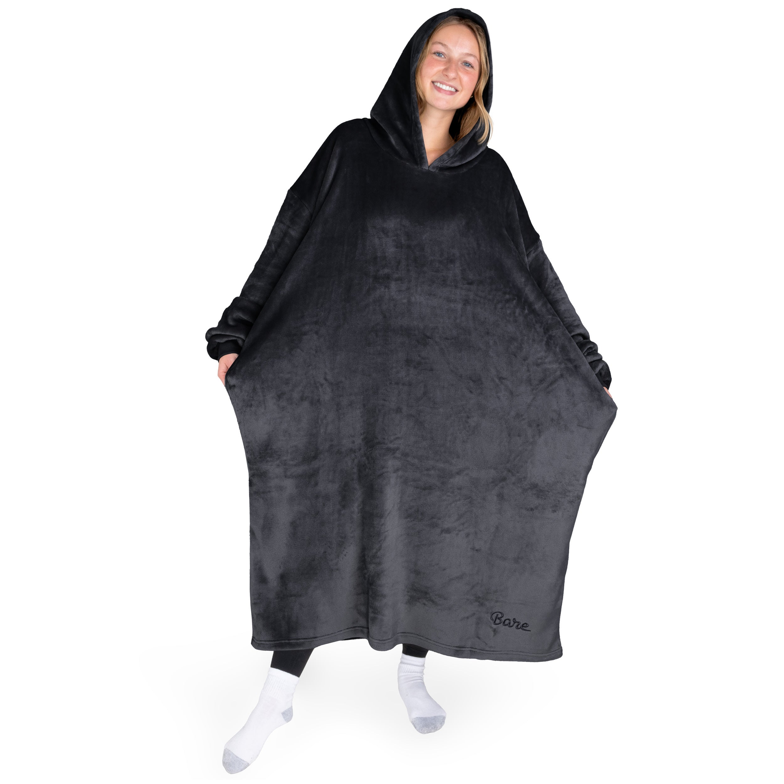 An adult with long microplush wearable blanket on