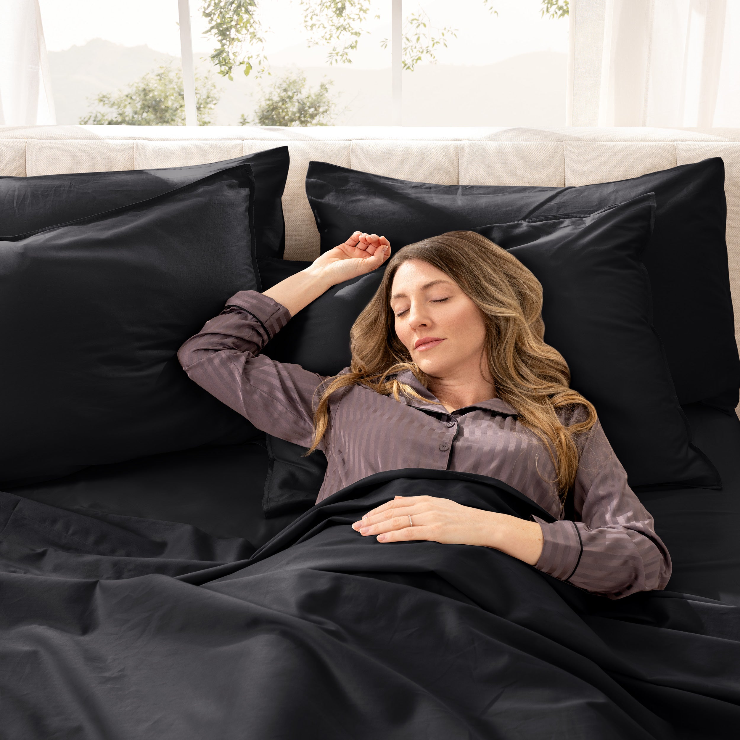 A woman sleeping on a bed made with organic cotton sateen sheets and pillowcases
