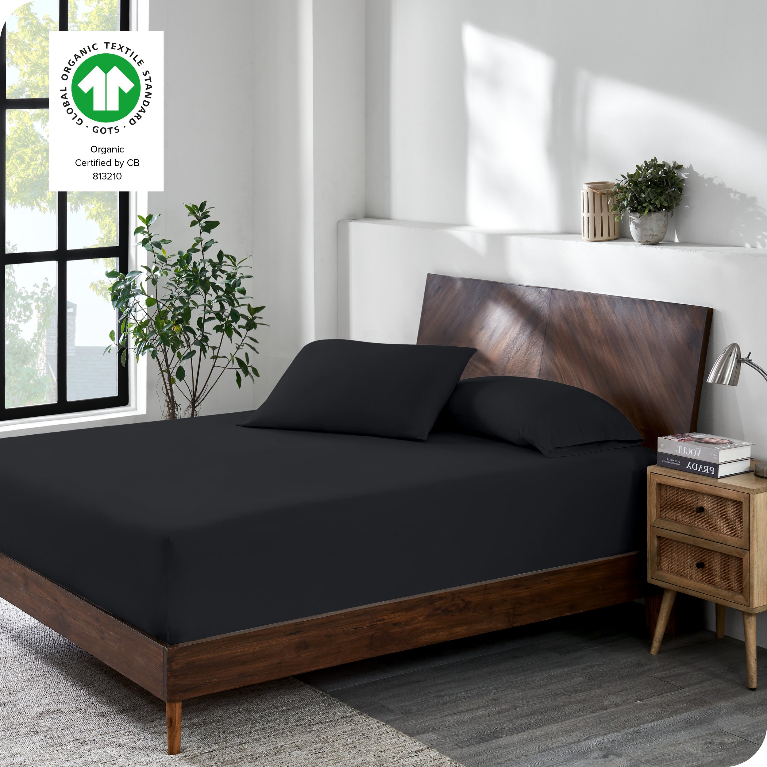 A bed made with a cotton jersey fitted sheet with 2 pillows near the headboard