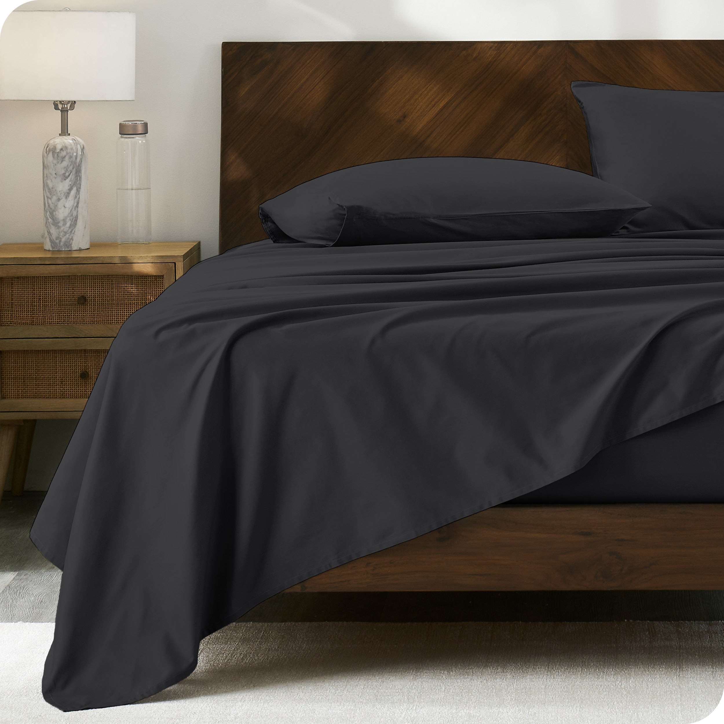 Percale sheet set on a bed with a wooden headboard