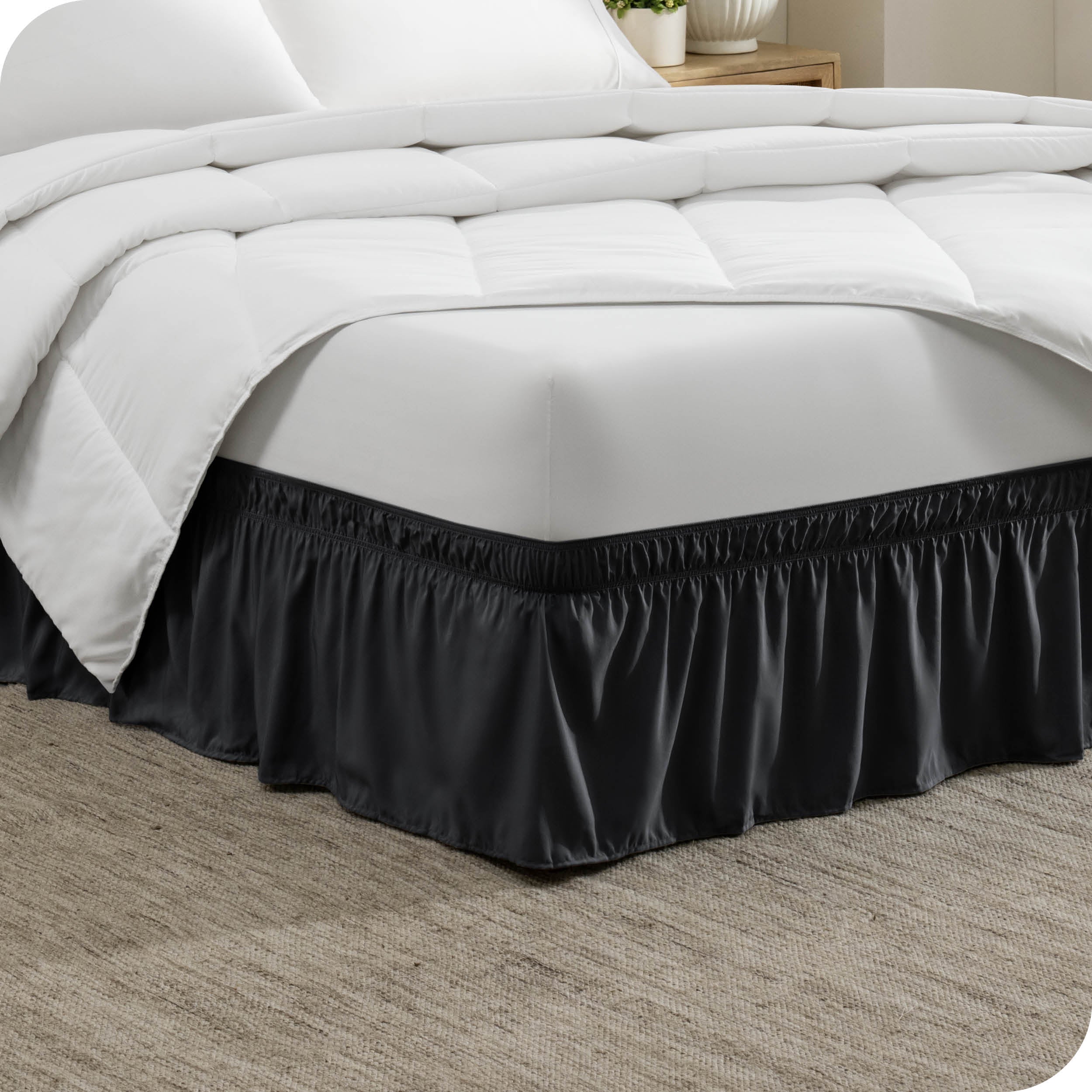 The corner of a bed with a polyester bed skirt on it