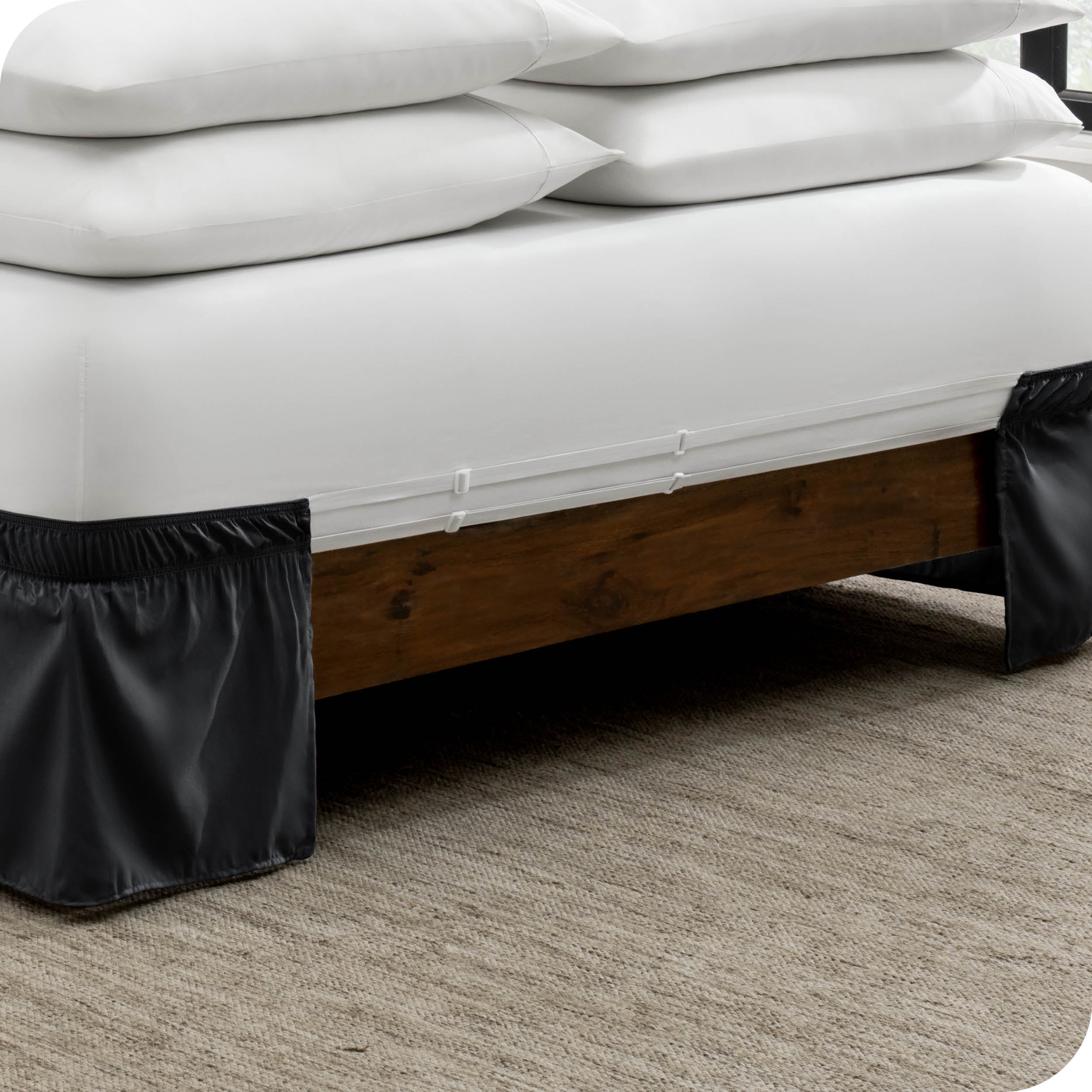 The adjustable elastic belt of a bed skirt wrapped around the mattress