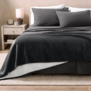 Black Sherpa Blanket laying on a bed folded over itself part way