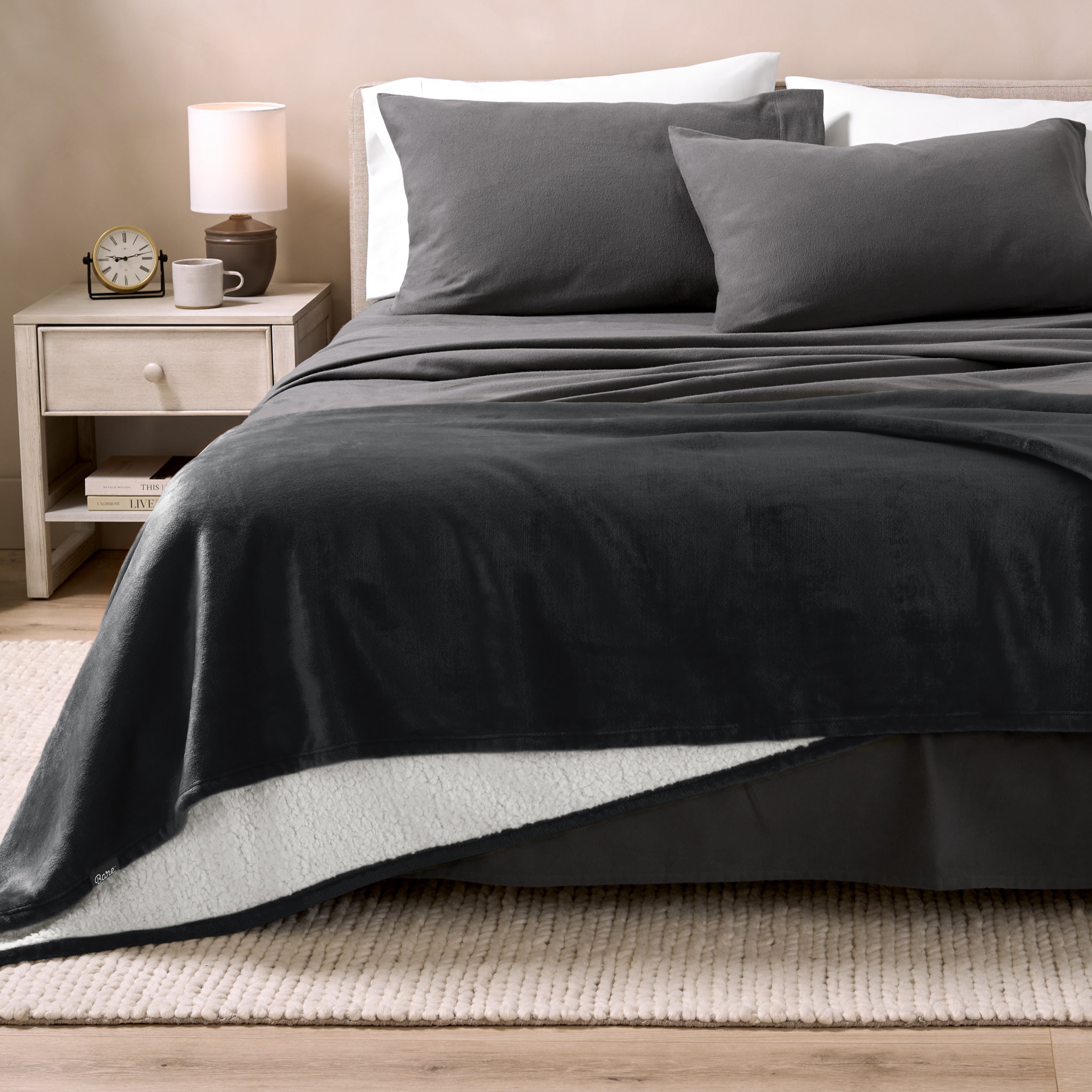 Black Sherpa Blanket laying on a bed folded over itself part way