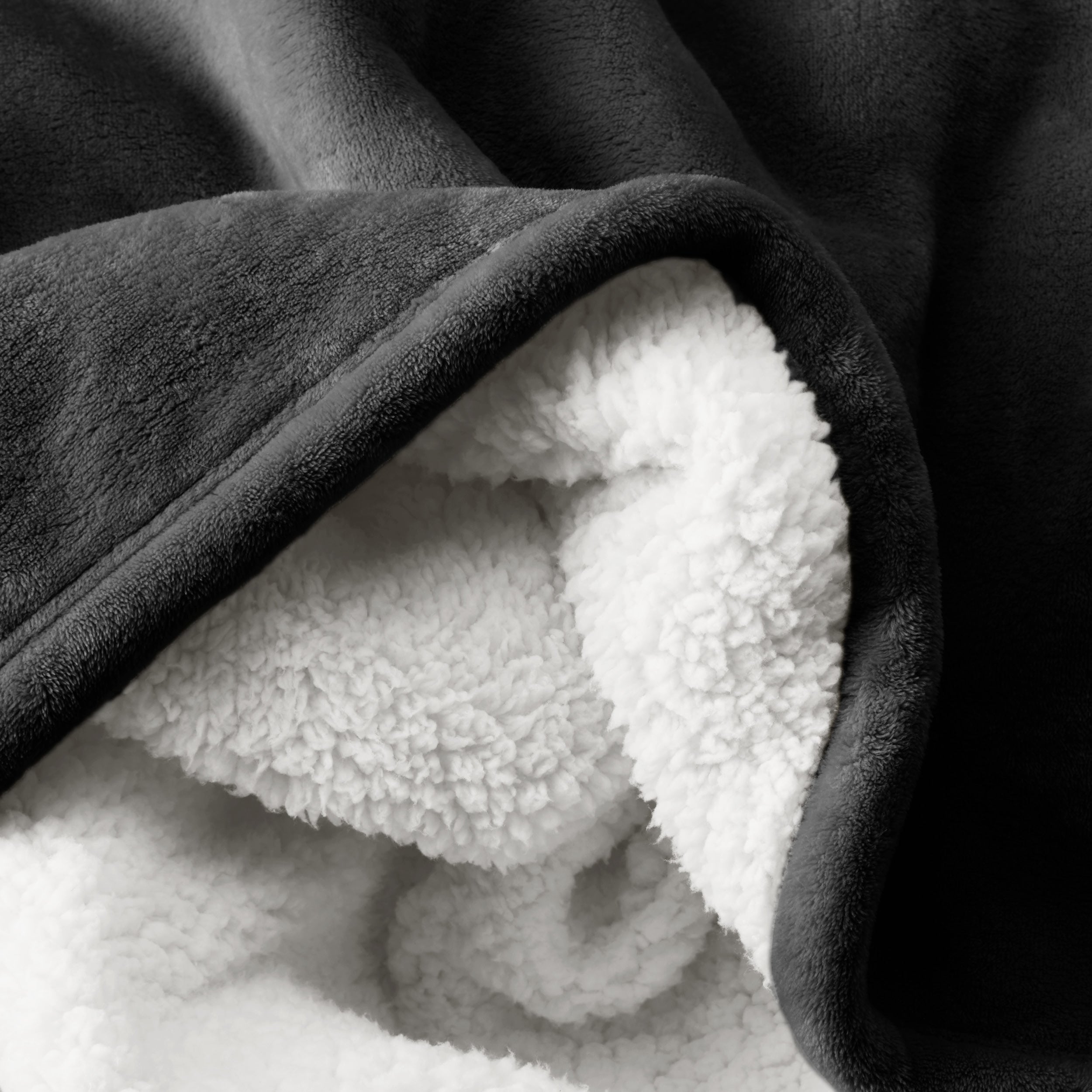 Close up of sherpa blanket showing texture of velvety soft side and sherpa backing