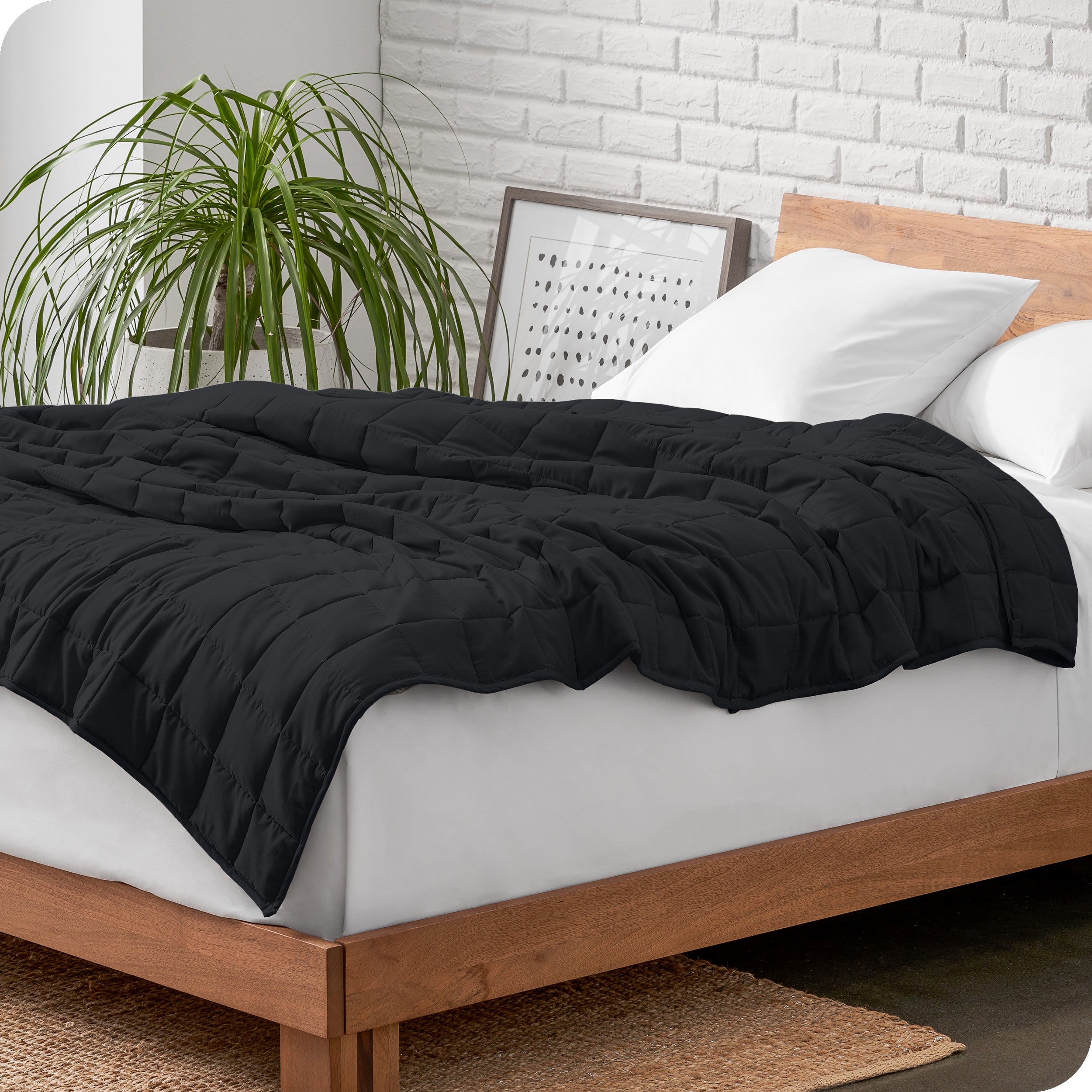 A cotton weighted blanket is loosely draped over a bed