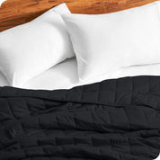 Close up of a weighted blanket on a bed with  2 pillows