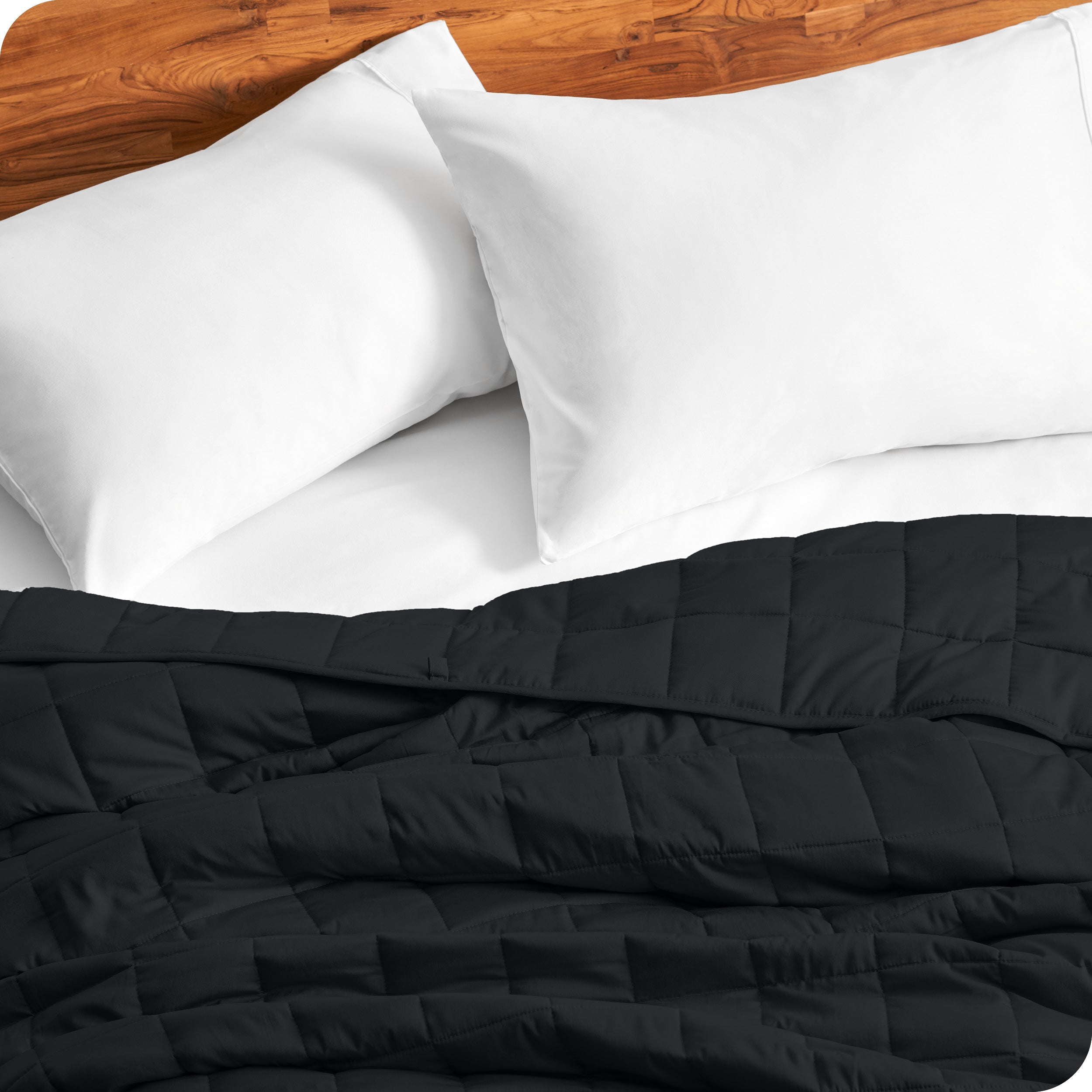 Close up of a weighted blanket on a bed with  2 pillows