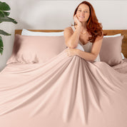 A smiling woman sitting on a bed