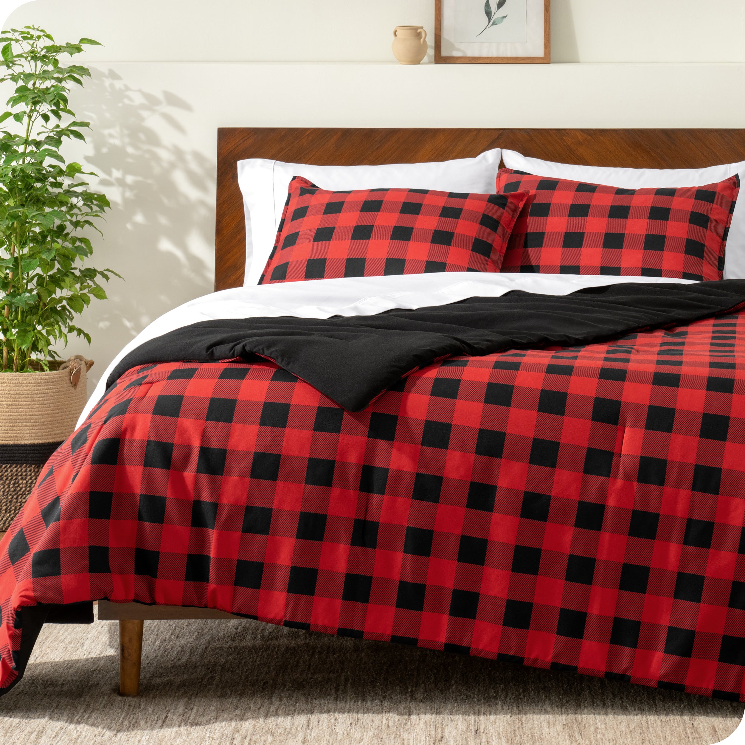 A comforter set on a bed with a dark wooden headboard