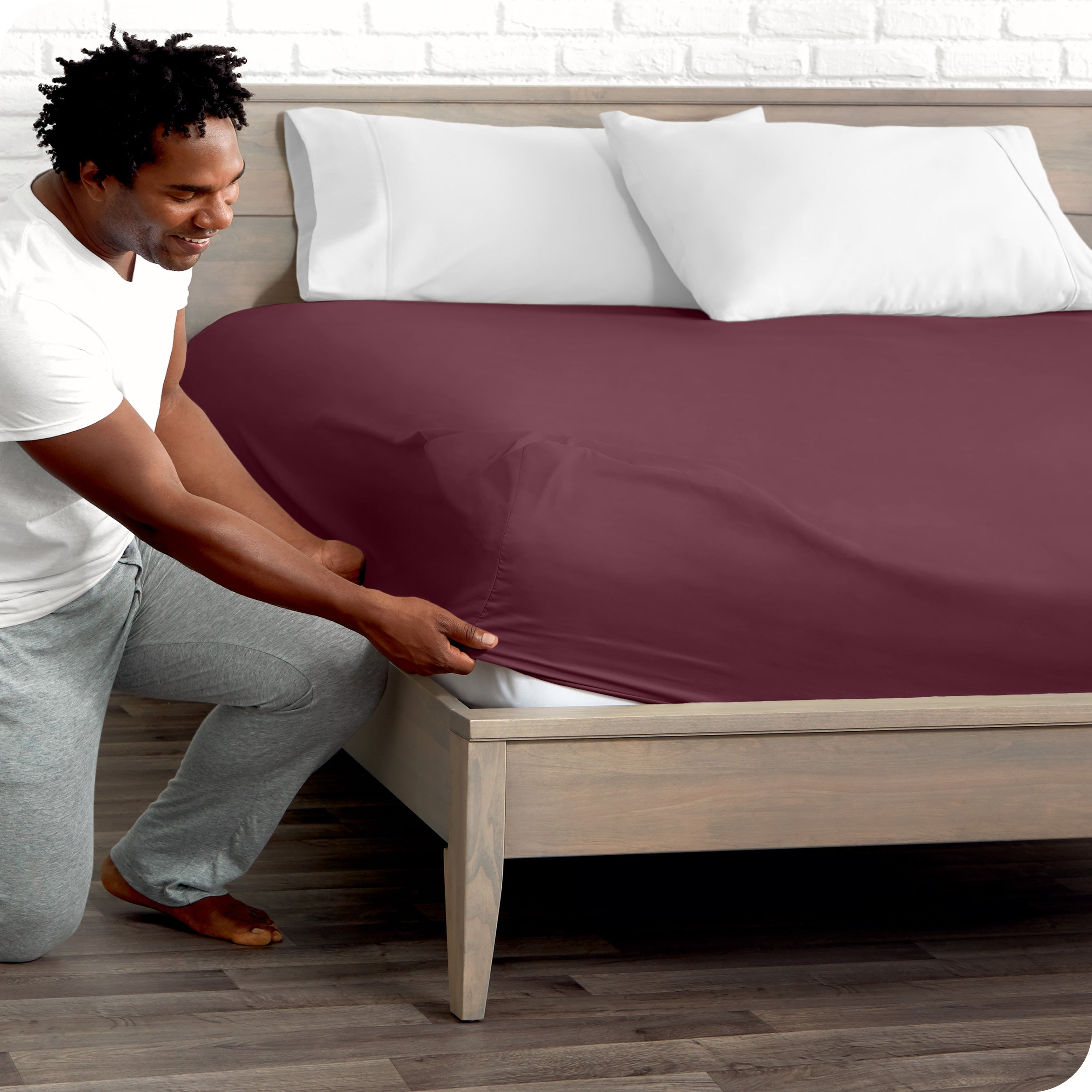 A man putting the microfiber fitted sheet on a mattress. 