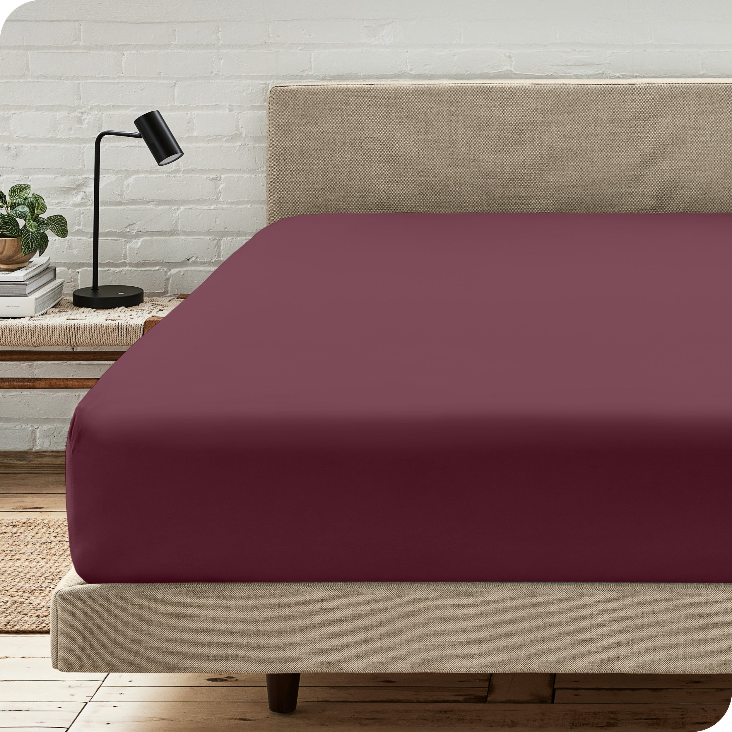 A bed with a microfiber fitted sheet on the mattress. 