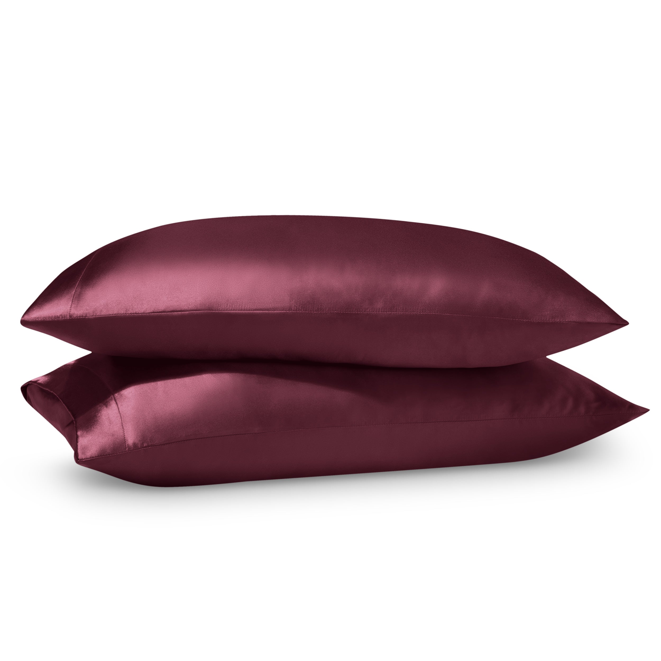 Two pillows on a white background with satin pillowcases on them.