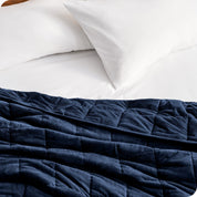 A close up view of a weighted blanket on a bed.