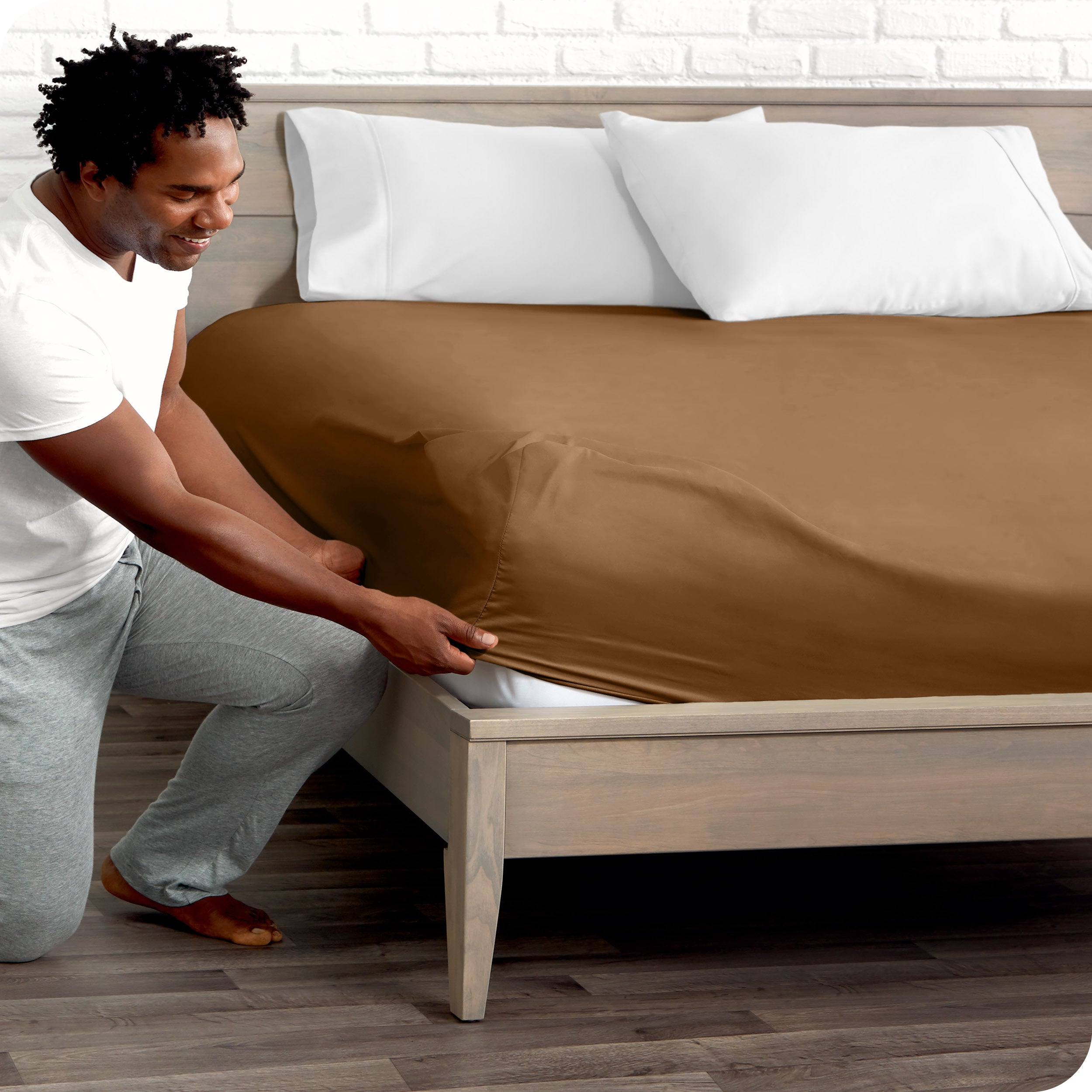 A man putting the microfiber fitted sheet on a mattress. 