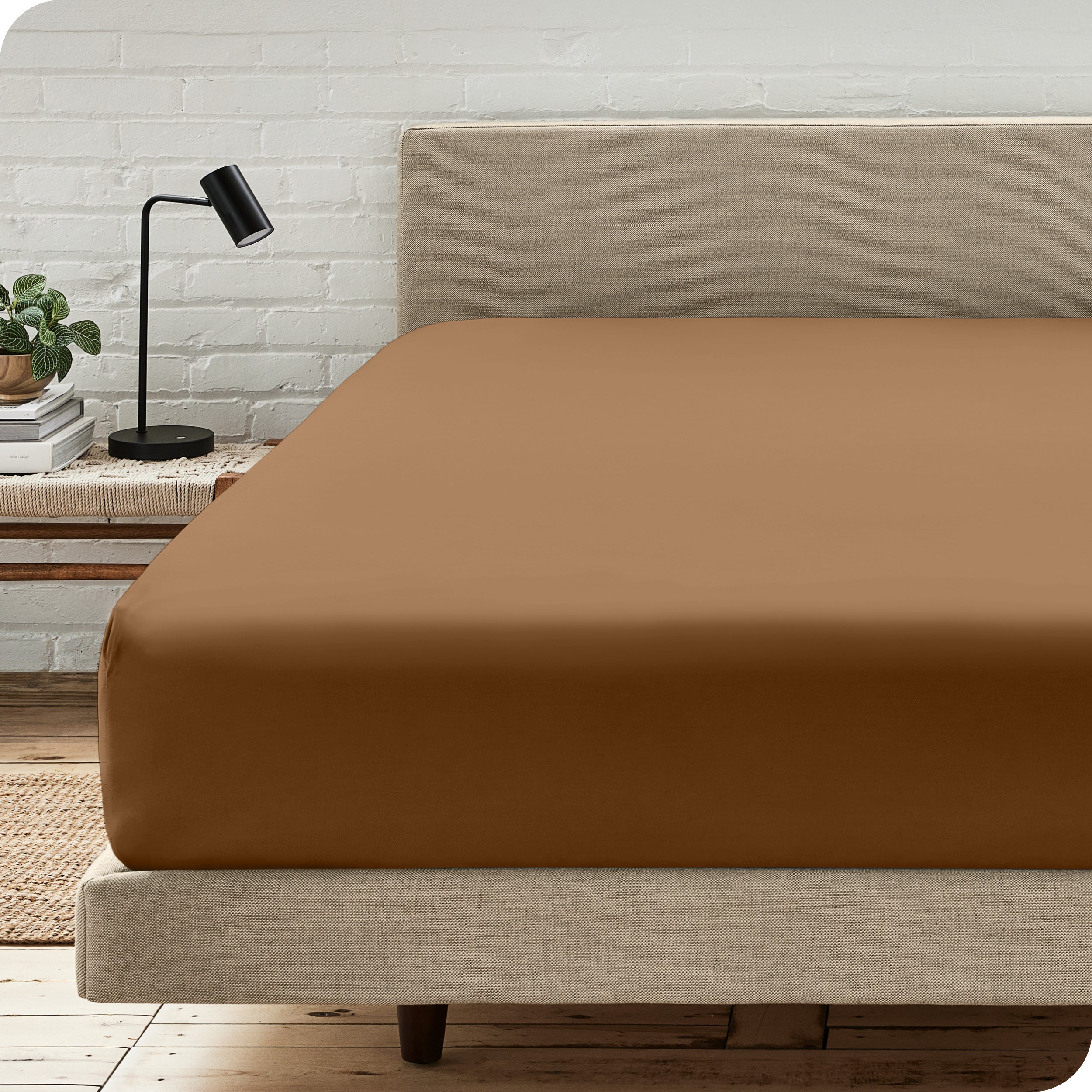 A bed with a microfiber fitted sheet on the mattress. 