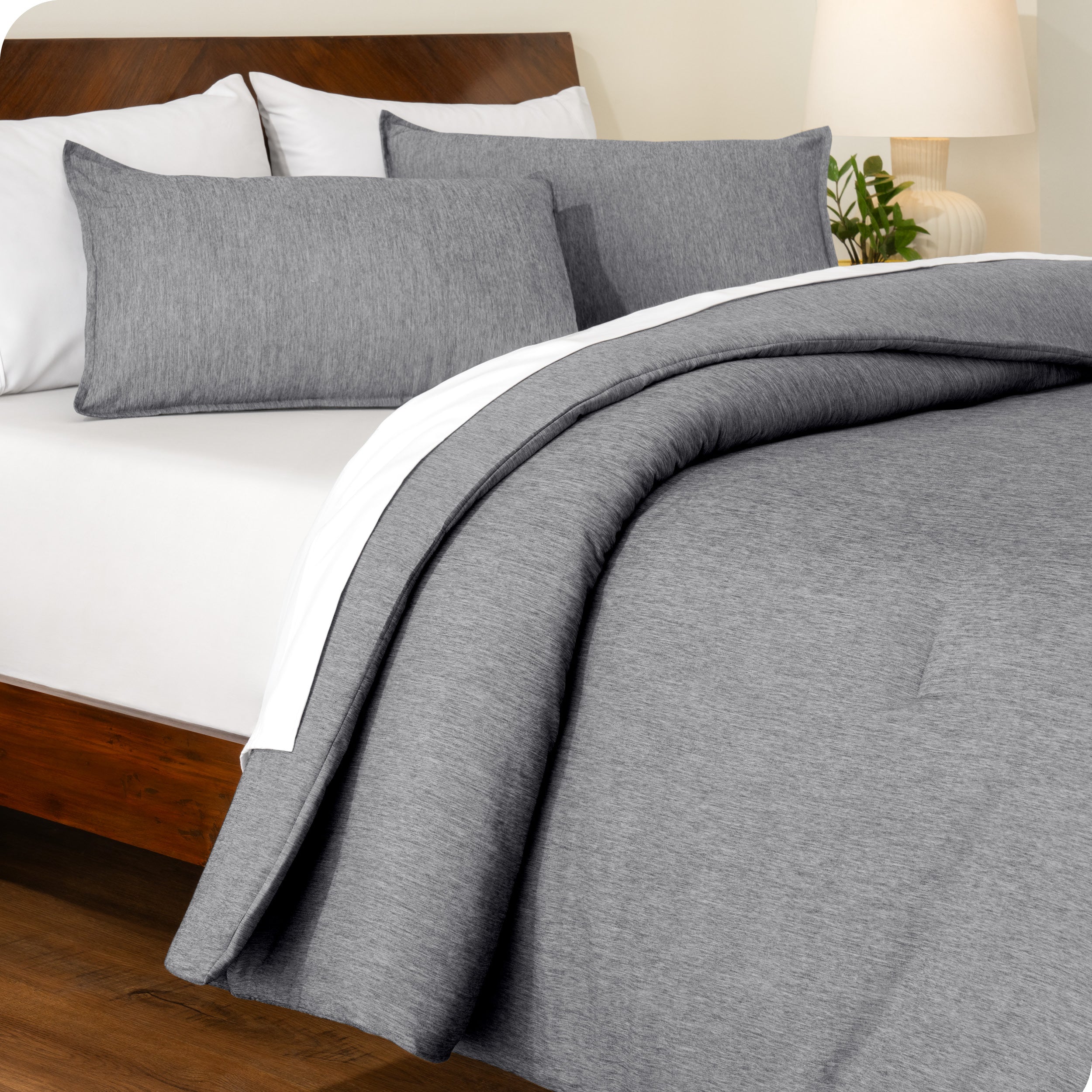 A side view of a modern bed with a comforter set and pillow shams on the bed
