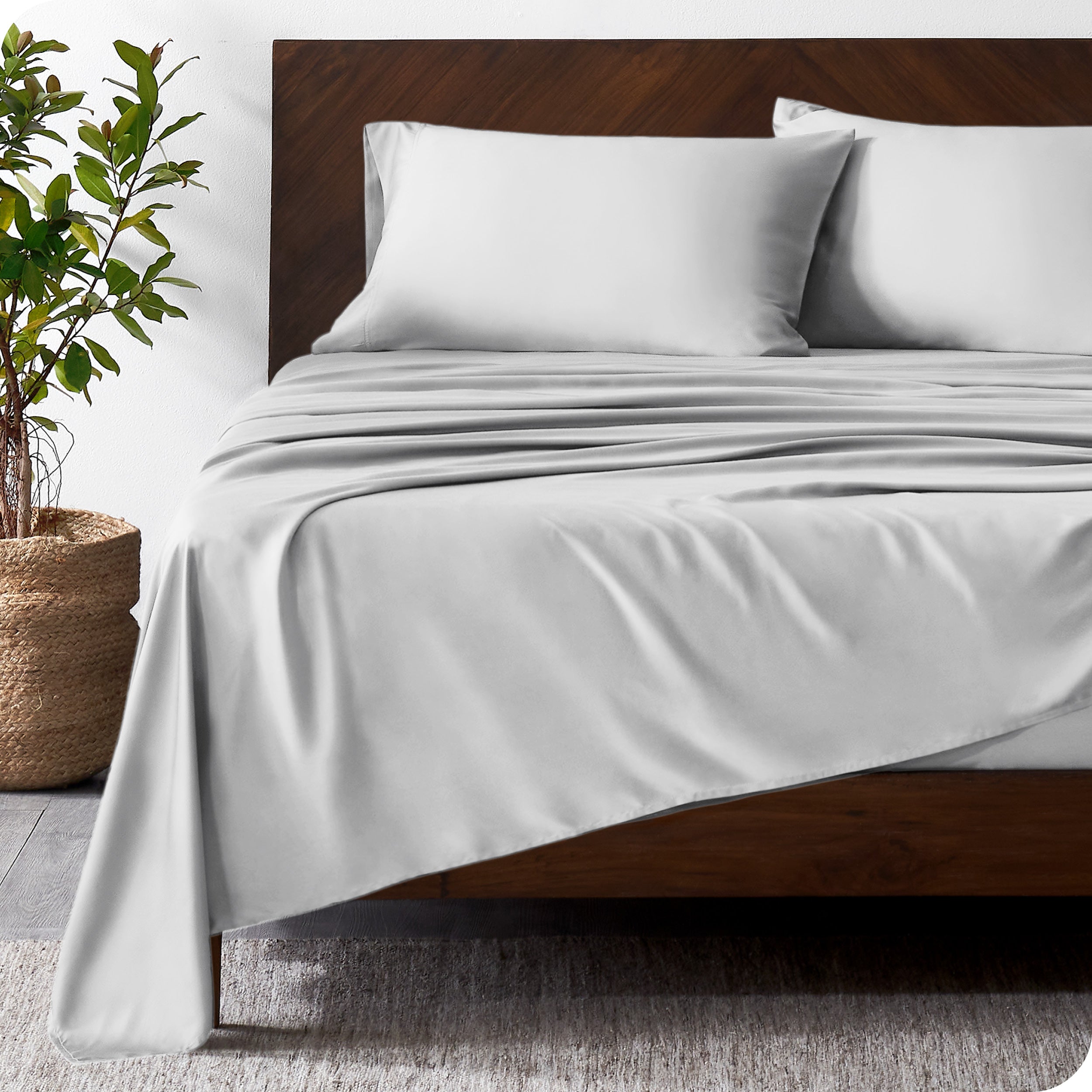 Wooden bed frame with bamboo sheets on the bed