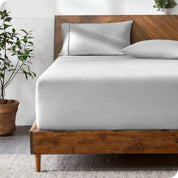 A modern bed with a fitted microfiber sheet made on the mattress. 