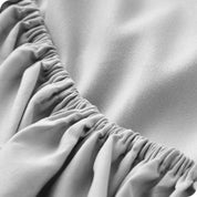 A close up of the elastic of a microfiber fitted sheet. 