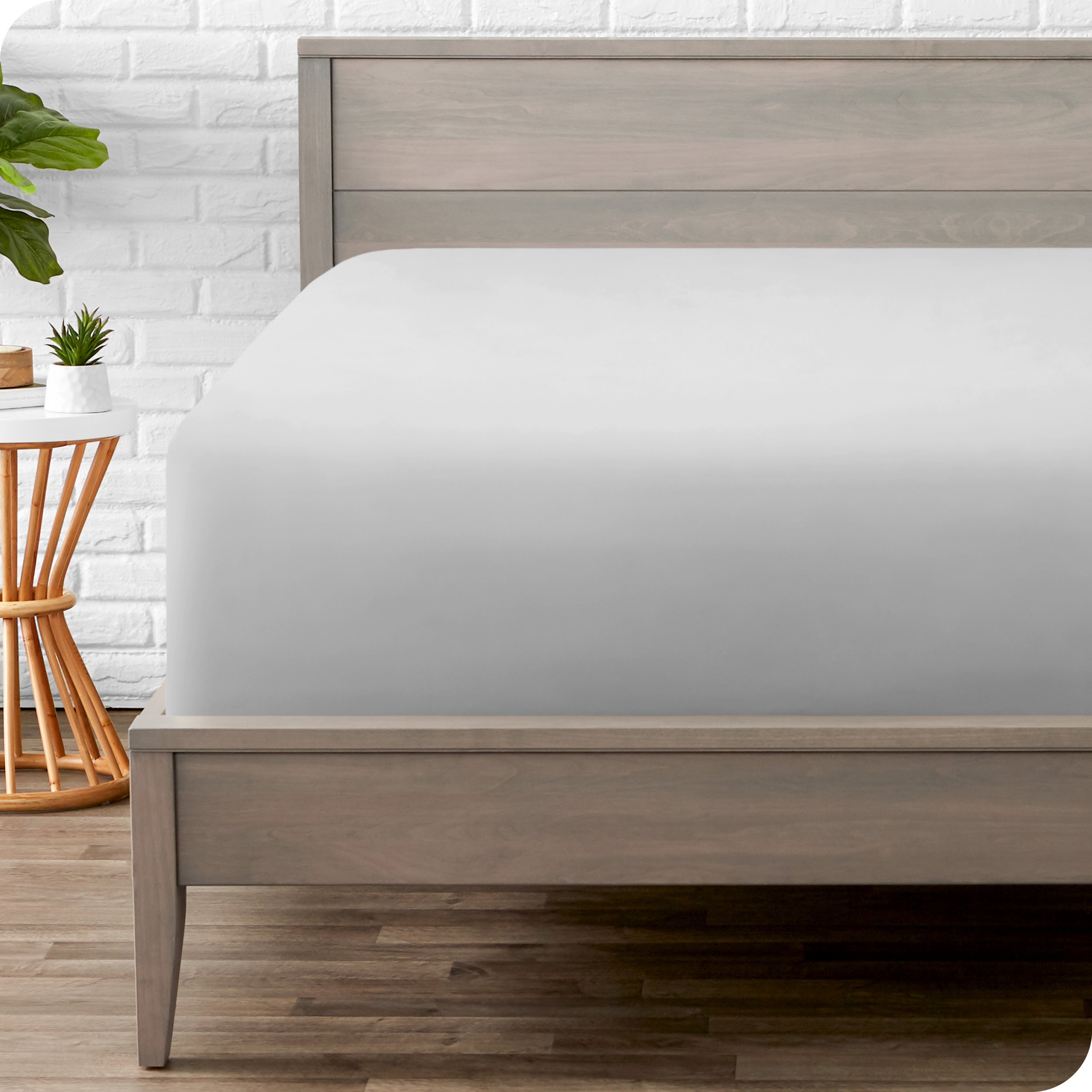 A modern bed with a fitted microfiber sheet on it
