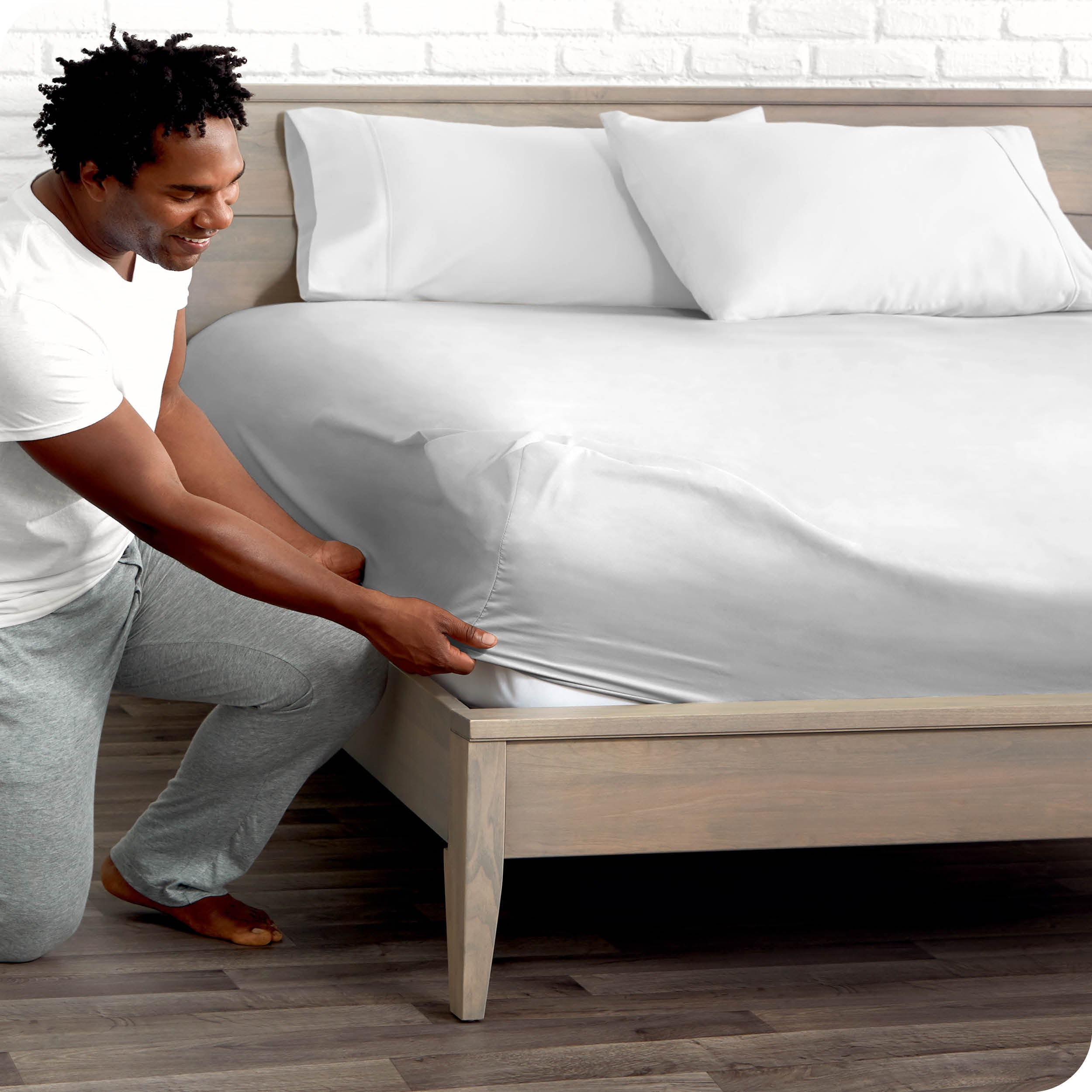 A man putting the microfiber fitted sheet on a mattress. 