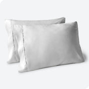 Two pillows on a white background with blue pillowcases on them