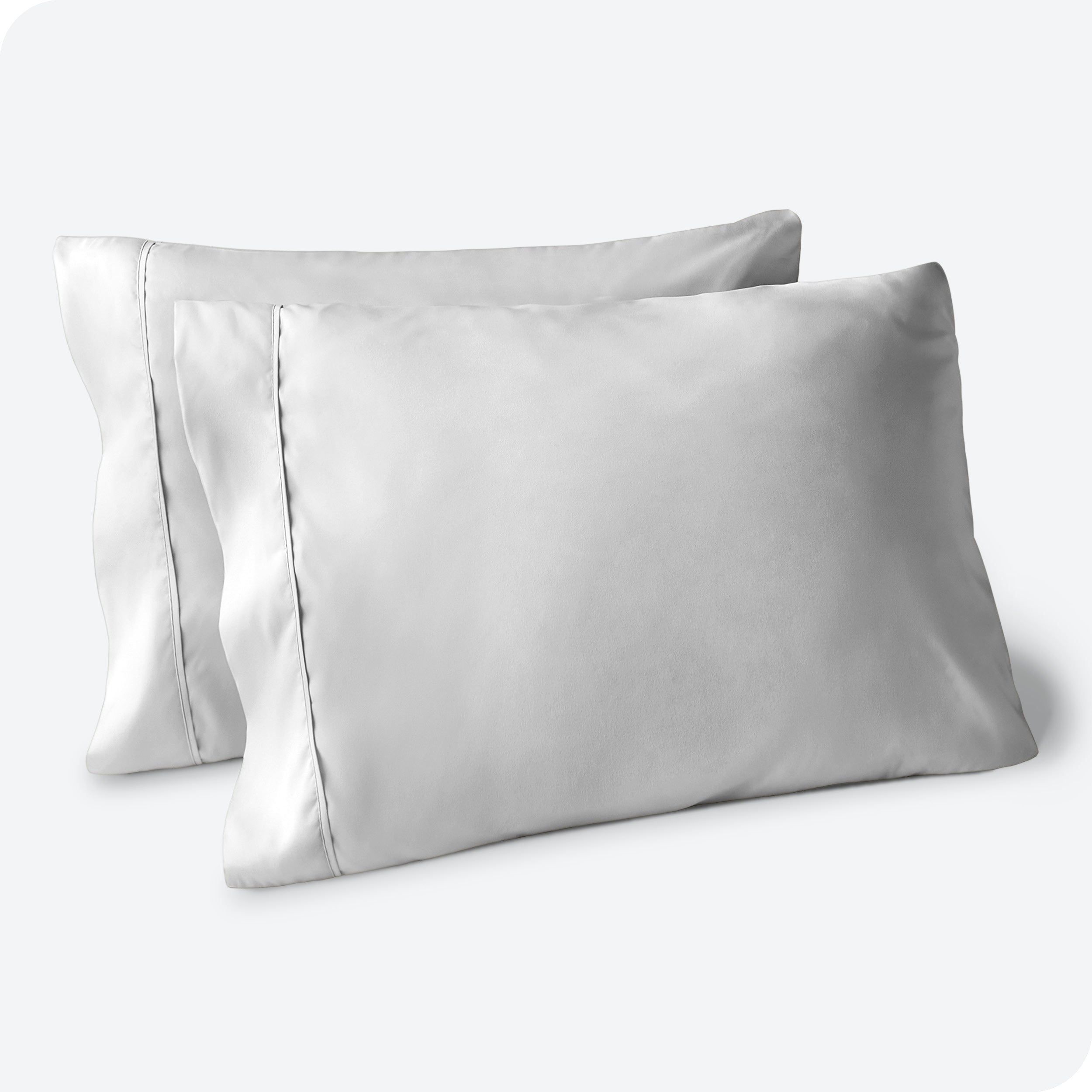 Two pillows on a white background with blue pillowcases on them