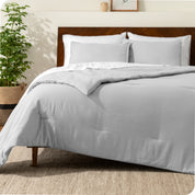 A comforter set on a bed with a dark wooden headboard