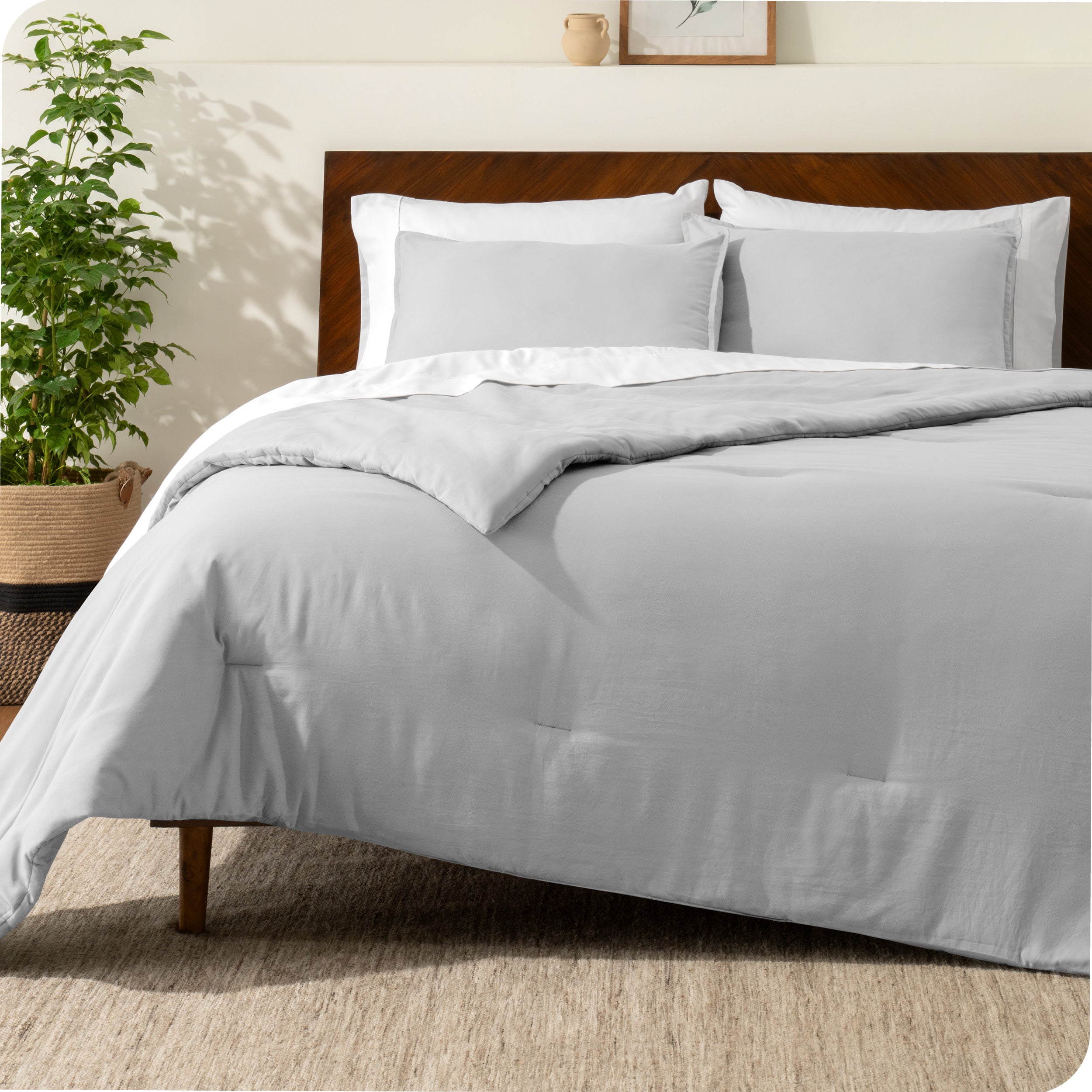A comforter set on a bed with a dark wooden headboard