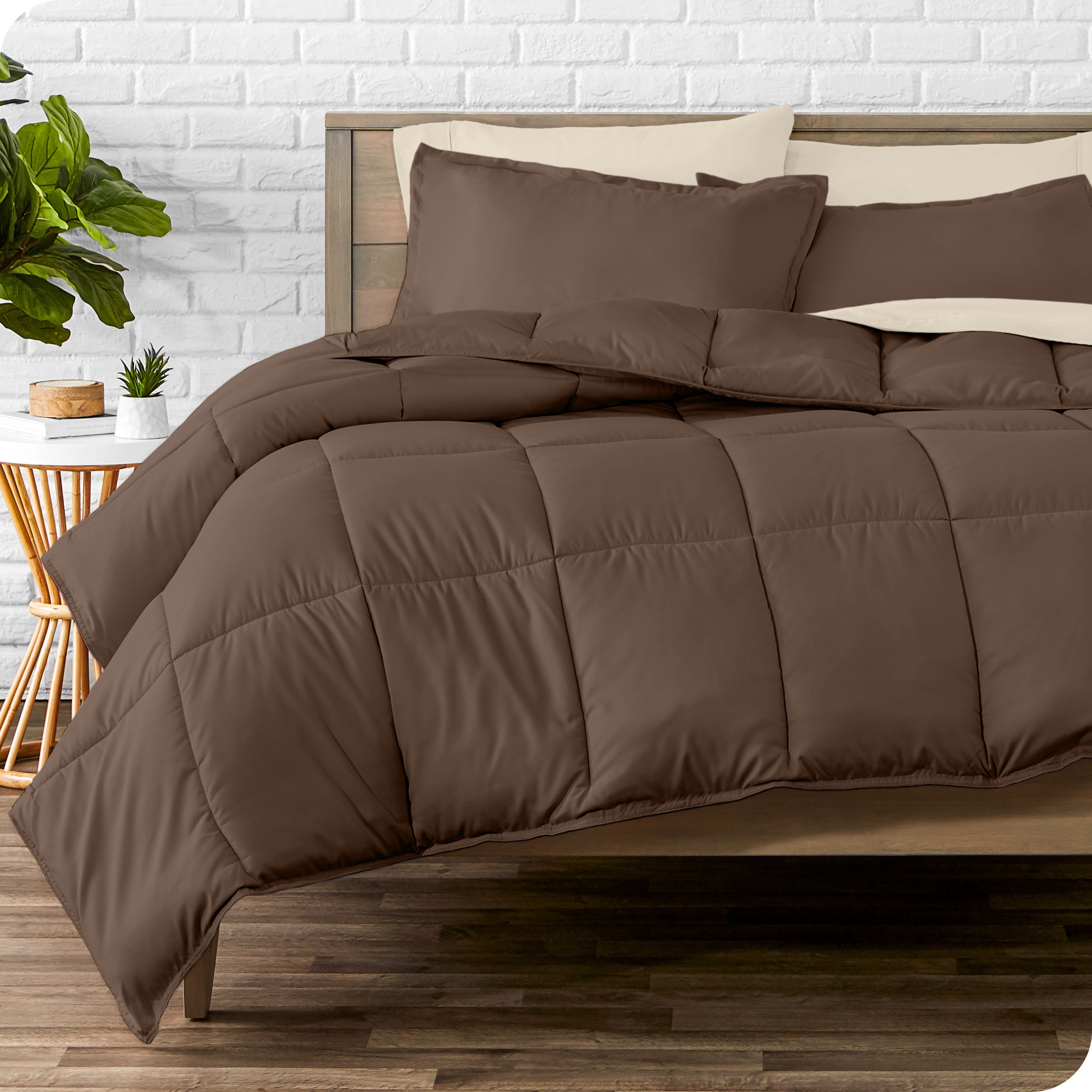 A wooden bed frame with sheets, pillow shams and a comforter on the bed