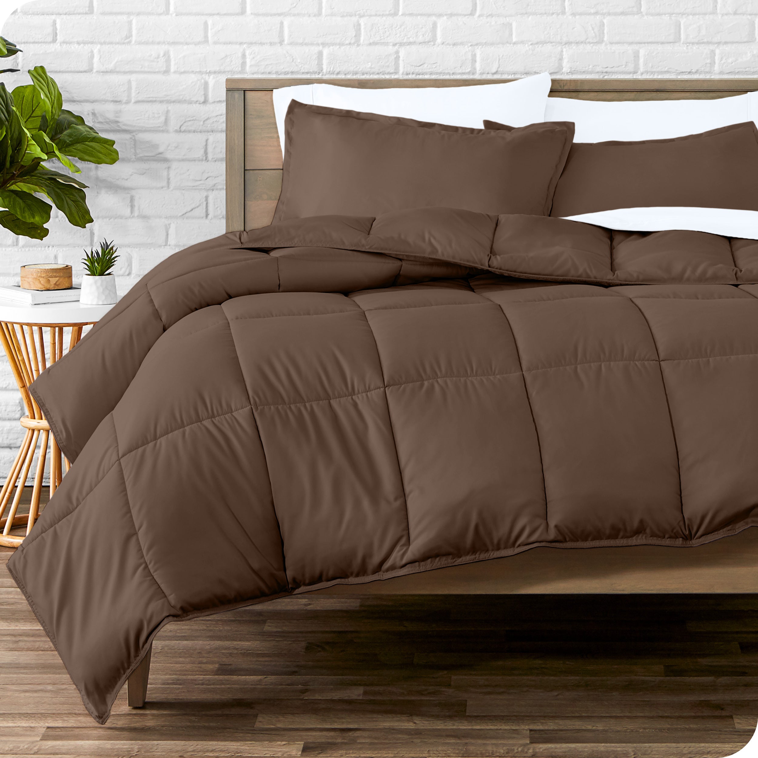 A wooden bed frame with sheets, pillow shams and a comforter on the bed