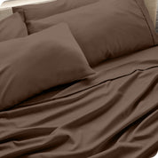 Close up of the microfiber bed sheets on a bed with four pillows.