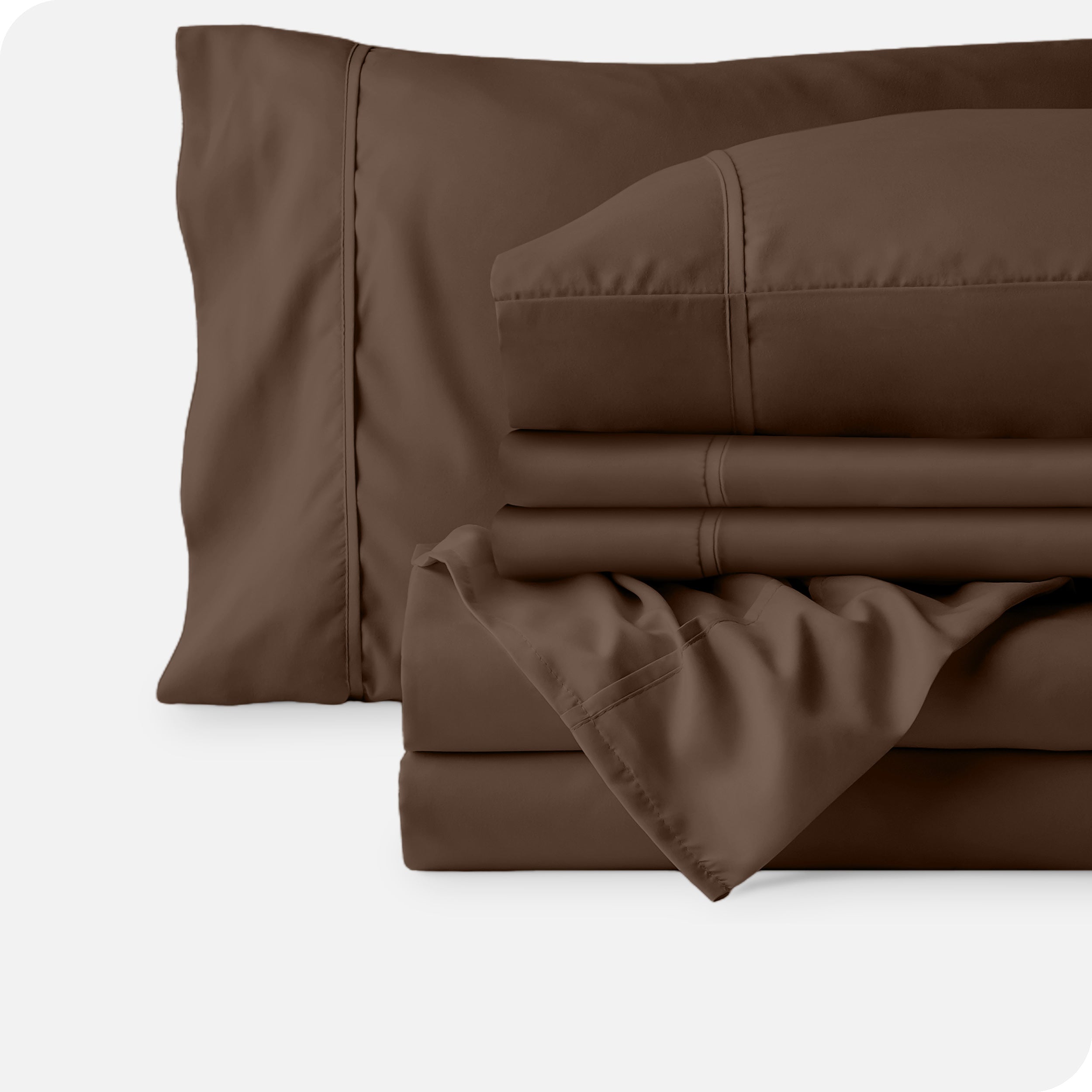 Microfiber sheets neatly folded with corner draped over, two folded pillowcases and two display pillows.