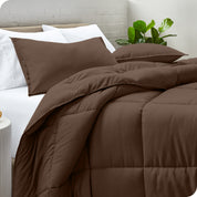 A side view of a modern bed with a comforter set and pillows on the bed