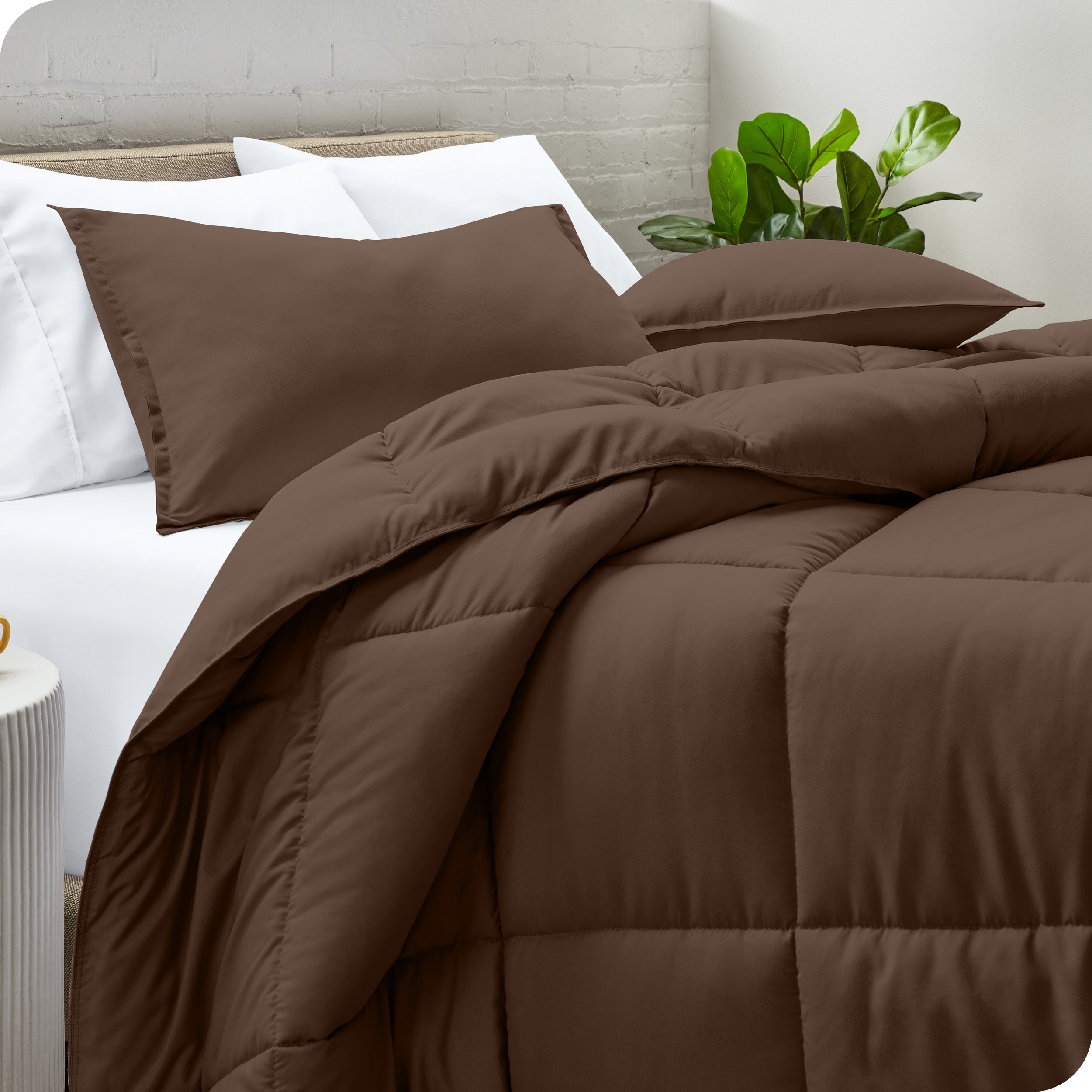 A side view of a modern bed with a comforter set and pillows on the bed