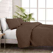 A coverlet set on a bed next to a window