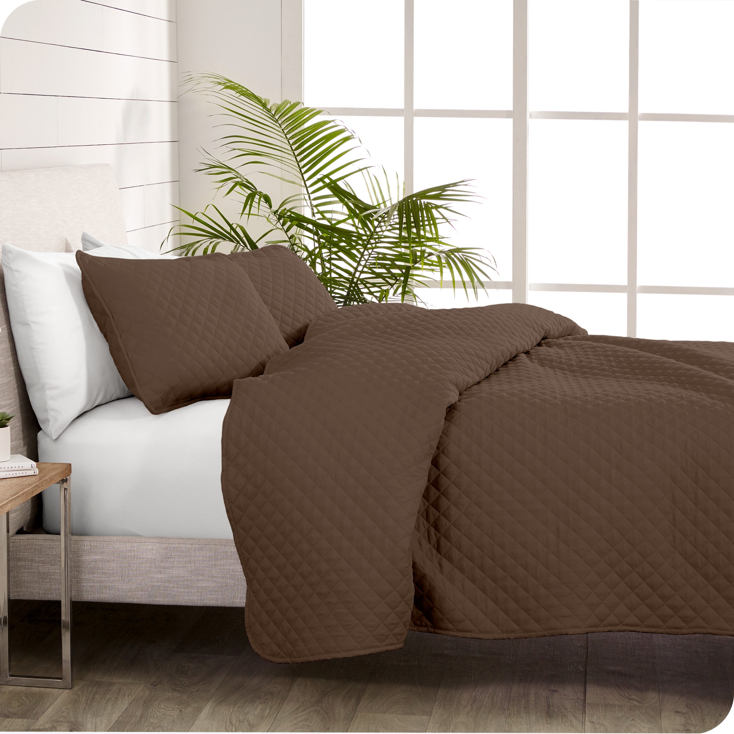A coverlet set on a bed next to a window