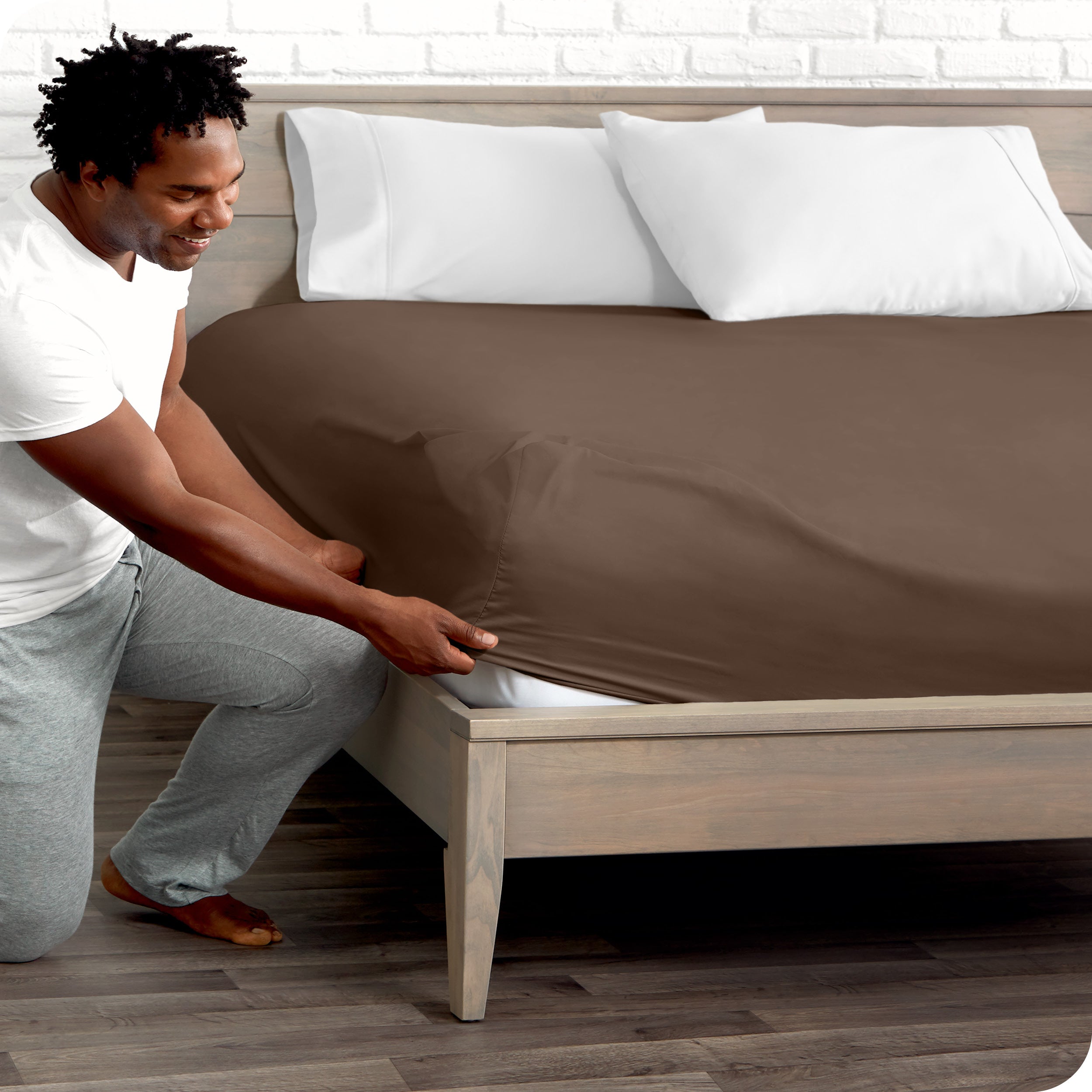 A man putting the microfiber fitted sheet on a mattress. 