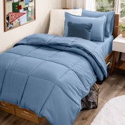 A college dorm room with a bed in a bag set on the mattress